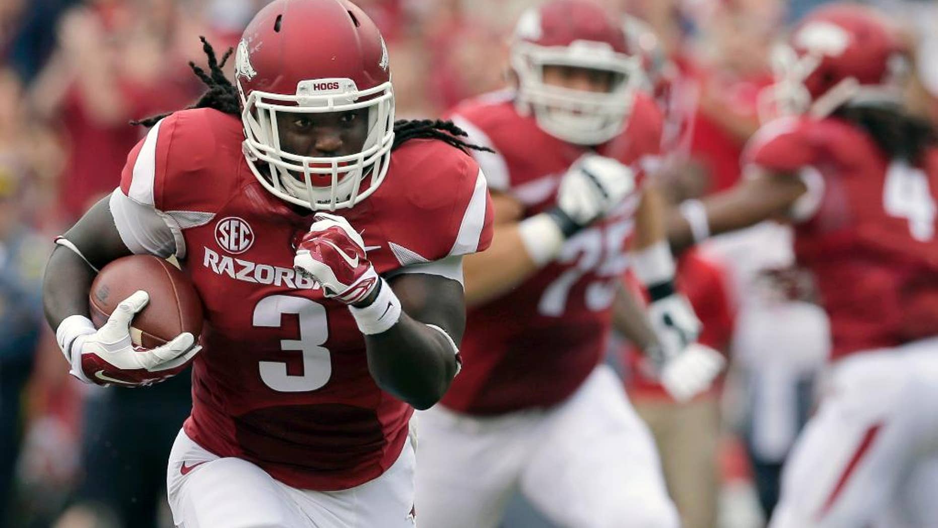 In this photo taken Sept. 6, 2014, Arkansas running back Alex Collins (3) carries in the first quarter of an NCAA college football game against Nicholls in Fayetteville, Ark. The Razorbacks, led by running backs Collins and Jonathan Williams hope to carry the momentum of Arkansas' 73-7 victory ahead to next week at Texas Tech. (AP Photo/Danny Johnston)