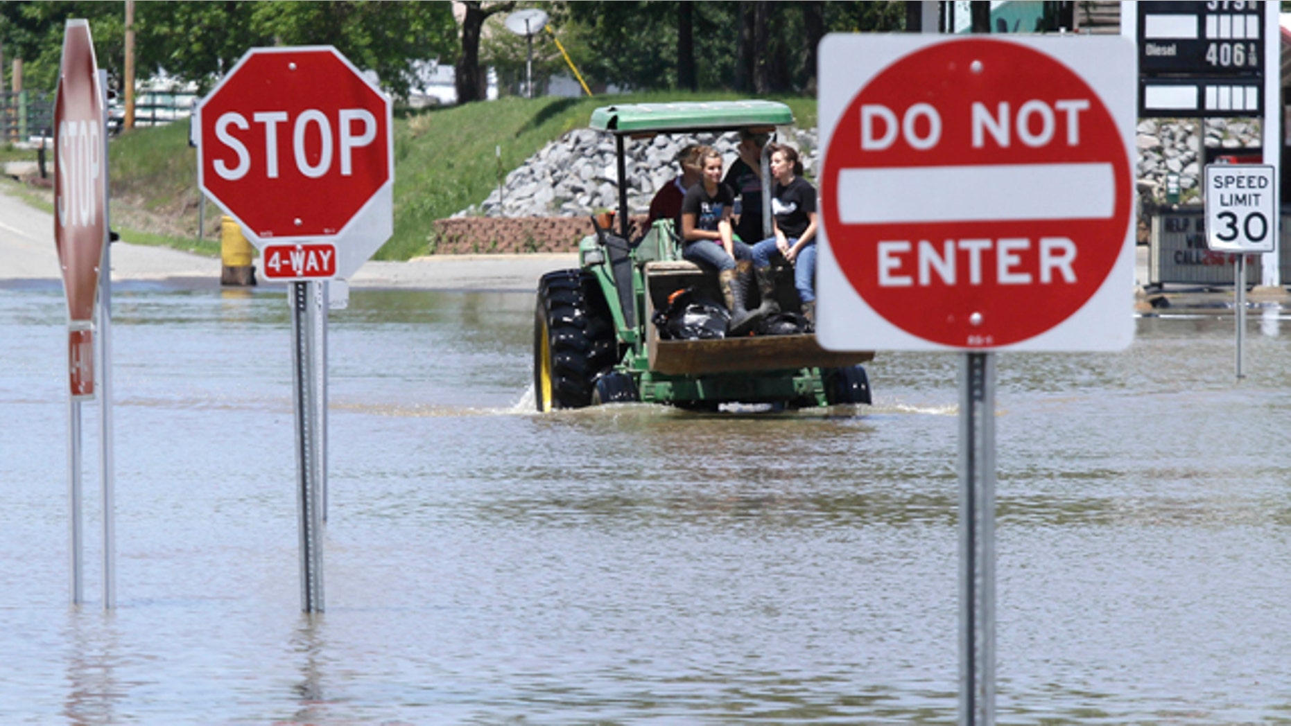 May 4: Two girls ride a tractor through a flooded intersection in Des Arc, Ark.