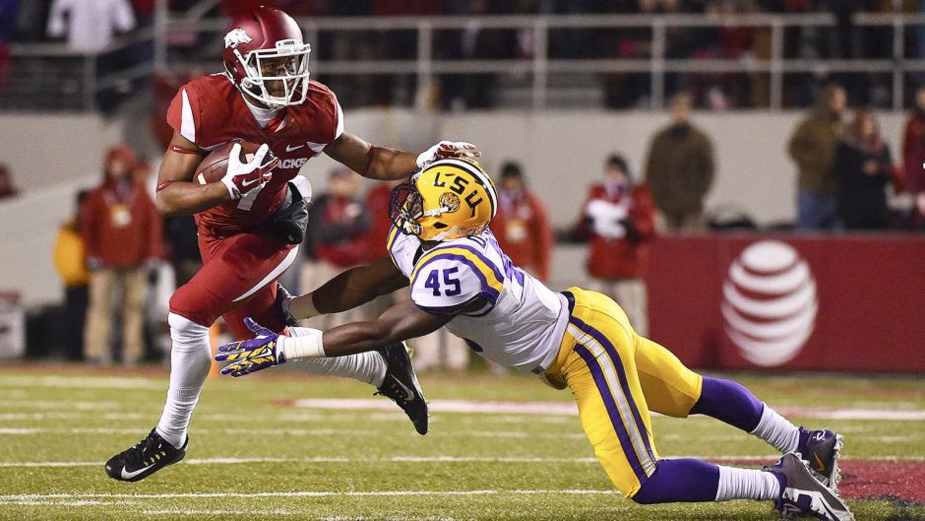 Nov 15, 2014; Fayetteville, AR, USA; Arkansas Razorbacks wide receiver Damon Mitchell (7) breaks the tackle of LSU Tigers linebacker Deion Jones (45) during the first half at Donald W. Reynolds Razorback Stadium. Mandatory Credit: Jasen Vinlove-USA TODAY Sports