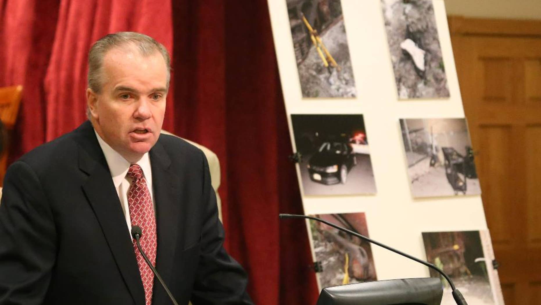 Acting Nassau County Police Commissioner Thomas Krumpter speaks with reporters on Aug. 27, 2015 in Mineola, N.Y., as he stands in front of a board showing crime scene photos of a botched burglary at an armored car company in Hicksville, N.Y. Authorities say a group of sophisticated burglars penetrated a vault of a Long Island armored car company and stole $1.8 million on Aug. 16, 2015, but were foiled by an alert police officer. (AP Photo/Mike Balsamo)