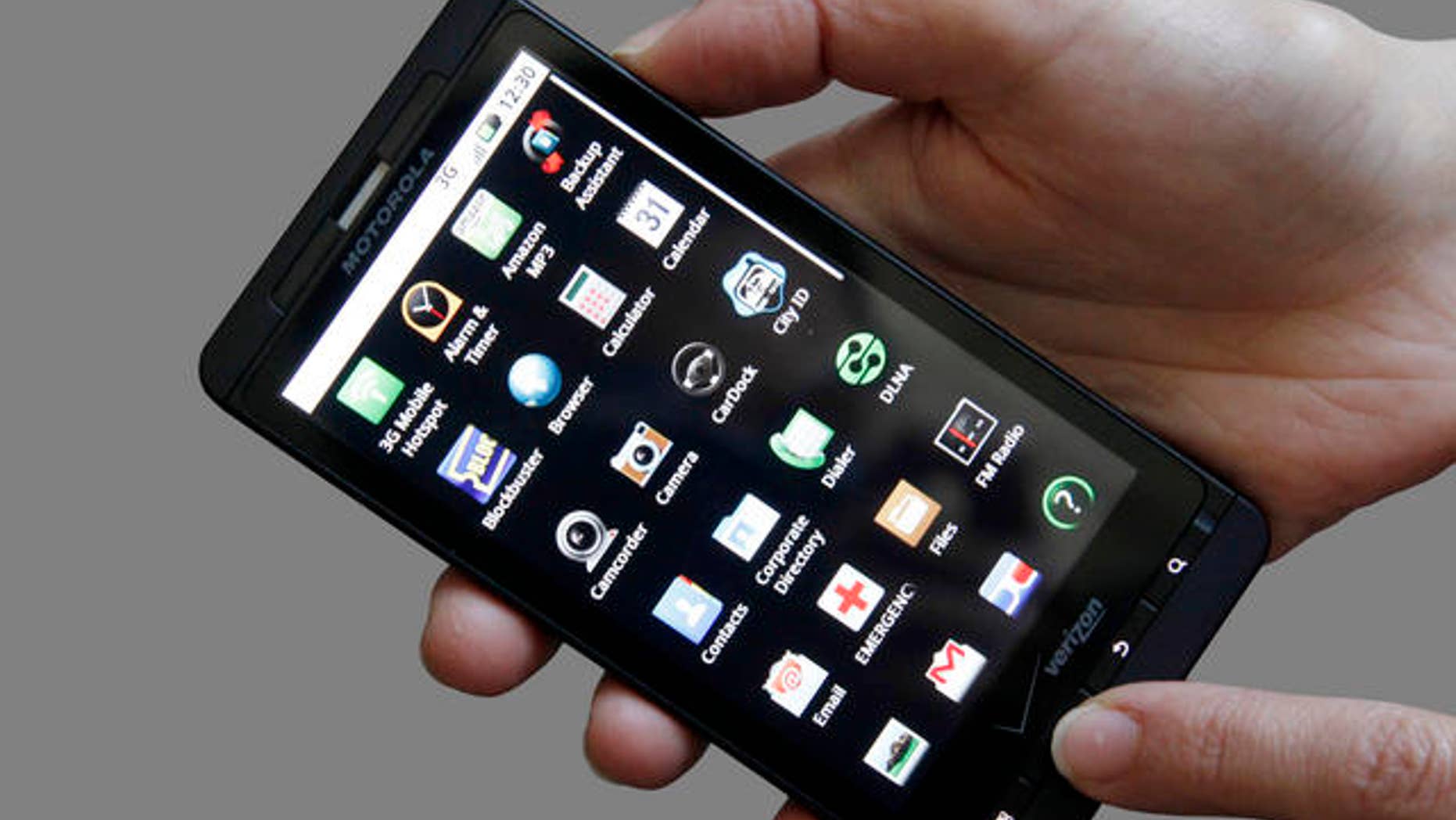 FILE - In this June 30, 2010 file photo, an Associated Press reporter holds the Droid X, the latest addition to Motorola Inc's smart phone line, during a product review in San Francisco. For decades, Motorola's products told the story of the march of electronics into the hands of consumers: car radios in the 1930s, TVs in the 1940s and cell phones in the 1980s. (AP Photo/Jeff Chiu, file)