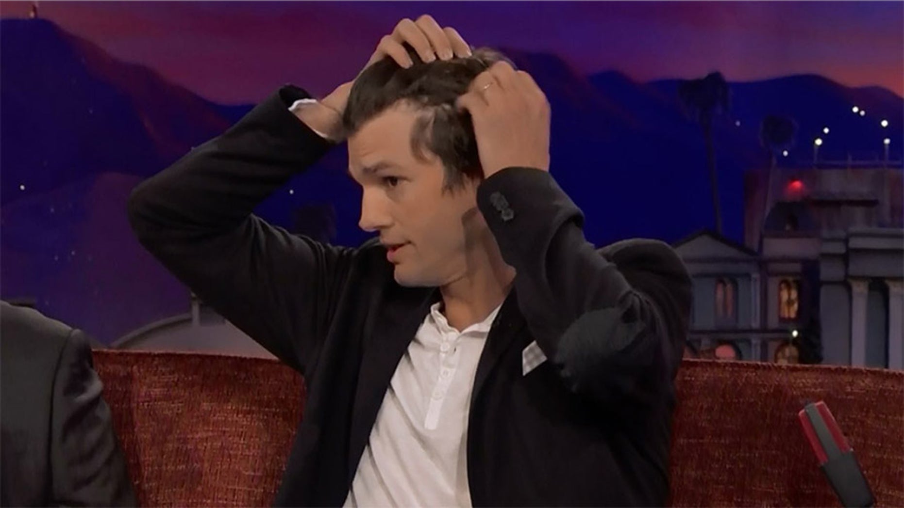 Ashton Kutcher revealed his receding hairline to TV host Conan O'Brien Monday night.