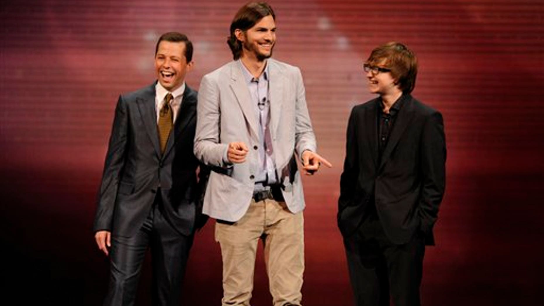 In this May 18, 2011 file publicity image released by CBS, the cast of "Two and a Half Men," from left, Jon Cryer, Ashton Kutcher, and Angus T. Jones are shown during their presentation at CBS' Upfronts (AP)