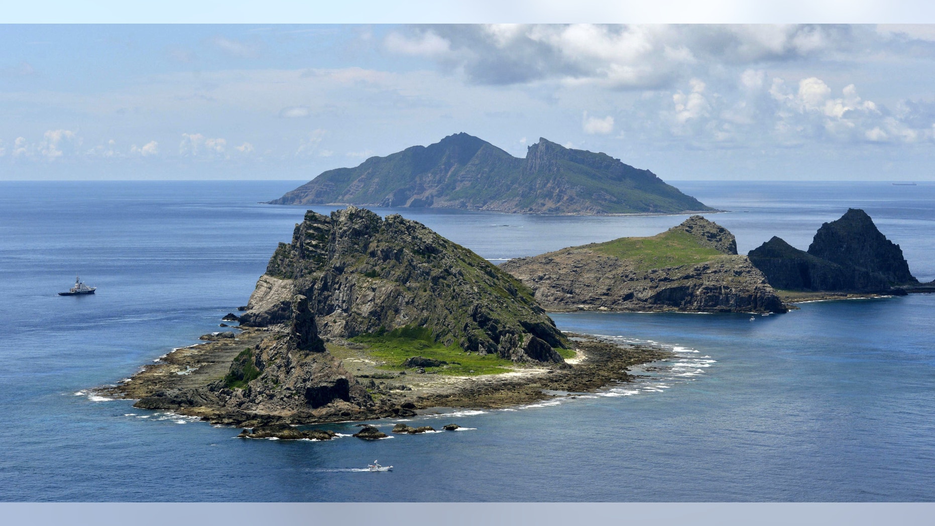 The survey ship Koyo Maru, left, chartered by Tokyo city officials, sails around Minamikojima, foreground, Kitakojima, middle right, and Uotsuri, background, the tiny islands in the East China Sea, called Senkaku in Japanese and Diaoyu in Chinese.