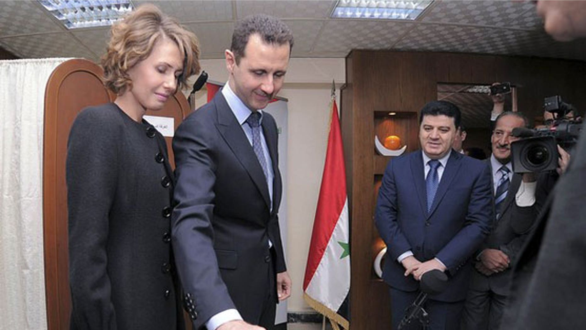 February 26, 2012: Syria's President Bashar al-Assad and his wife Asma vote during a referendum on a new constitution at a polling station in a Syrian TV station building in Damascus.