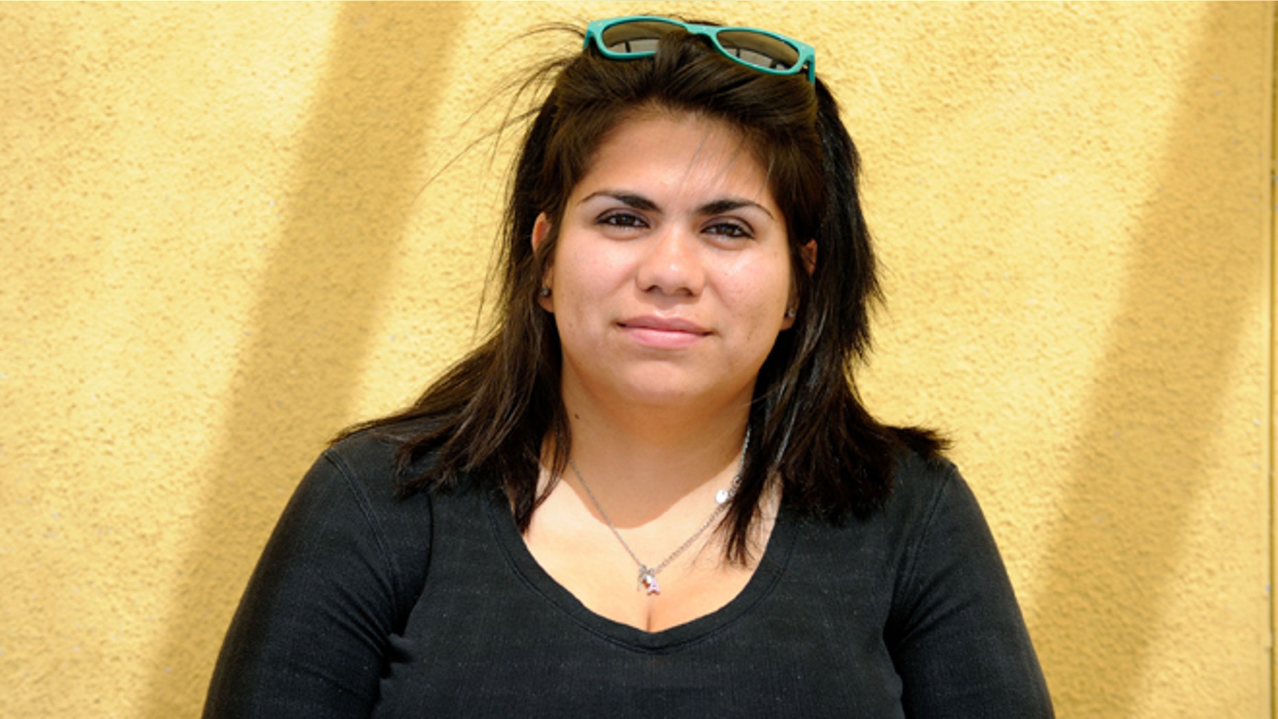 FILE - Astrid Silva poses as she waits for her number to be called to renew her passport at the Mexican Consulate in Las Vegas in this Friday, June 22, 2012 file photo. The young woman who has led immigration reform efforts buried her face in her father's shoulder, standing side-by-side against a wall, as the president mentioned the time when Silva couldn't return to Mexico to be at her grandmother's funeral. The 26-year-old's tears didn't abate as she went from interview to interview in front of cameras and microphones in a crowded Las Vegas office to tell her story once more, seconds after Obama finished telling the country about his plan to offer protections to nearly 5 million immigrants, including deferring deportations for some. (AP Photo/Las Vegas Review-Journal, David Becker, File)