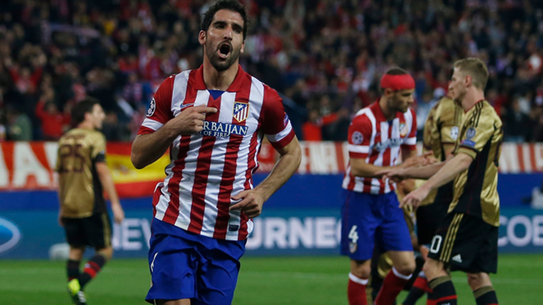 Atletico's Raul Garcia, centre, celebrates his goal during a Champions League last 16 second leg soccer match between Atletico Madrid and AC Milan, at the Vicente Calderon stadium in Madrid, Tuesday, March 11, 2014. (AP Photo/Andres Kudacki)