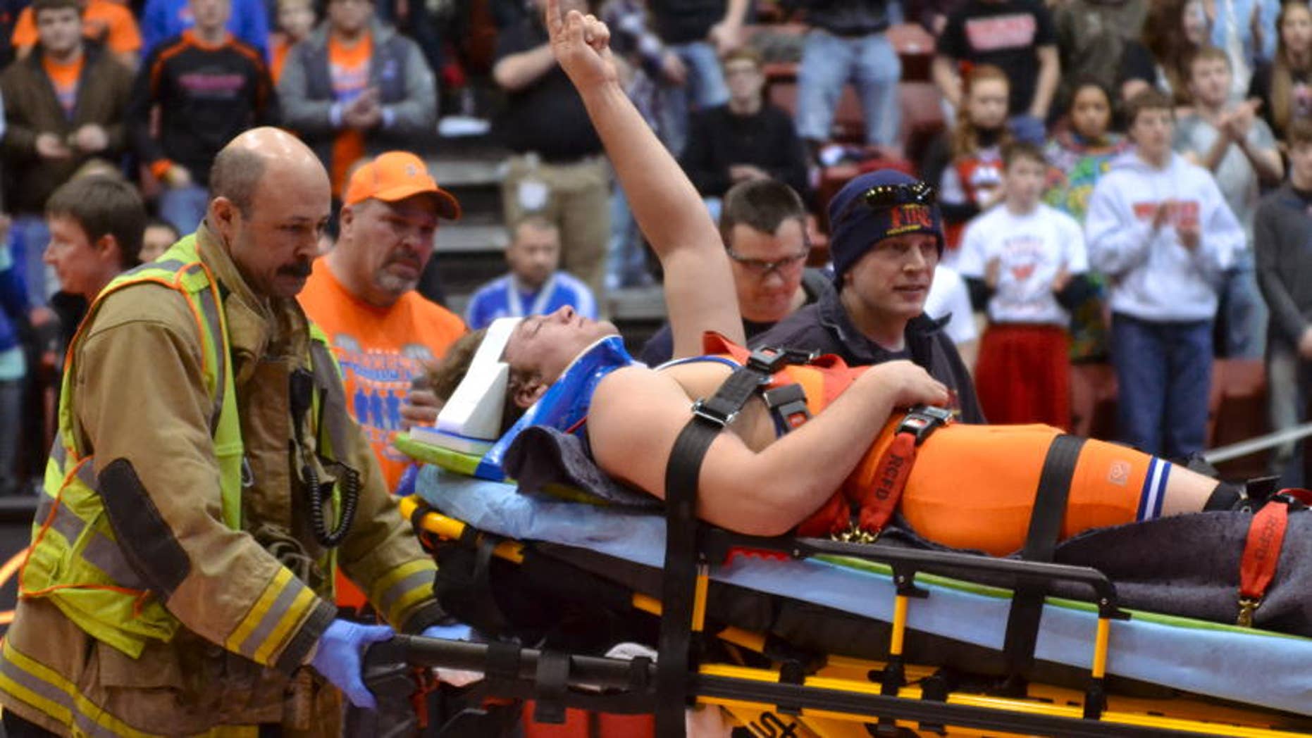 Parkston's Austin Bertram, center, is carried off the mat by medical personnel as he waves to the crowd giving him a standing ovation at the Class B state wrestling tournament on Saturday in Rapid City. (Garrick Hodge/Republic)