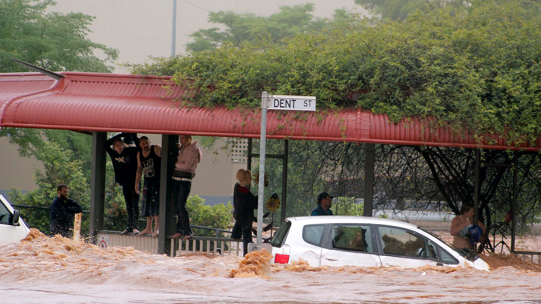 Jan. 10, 2011: People cling to railings and metal fences on a flooded street in Toowoomba, Australia, during a flash flood. Flash floods swept through the northeastern Australian community killing one woman, trapping others in cars and leaving some clinging to trees as relentless rains brought more misery to a region battling its worst flooding in decades. (AP)