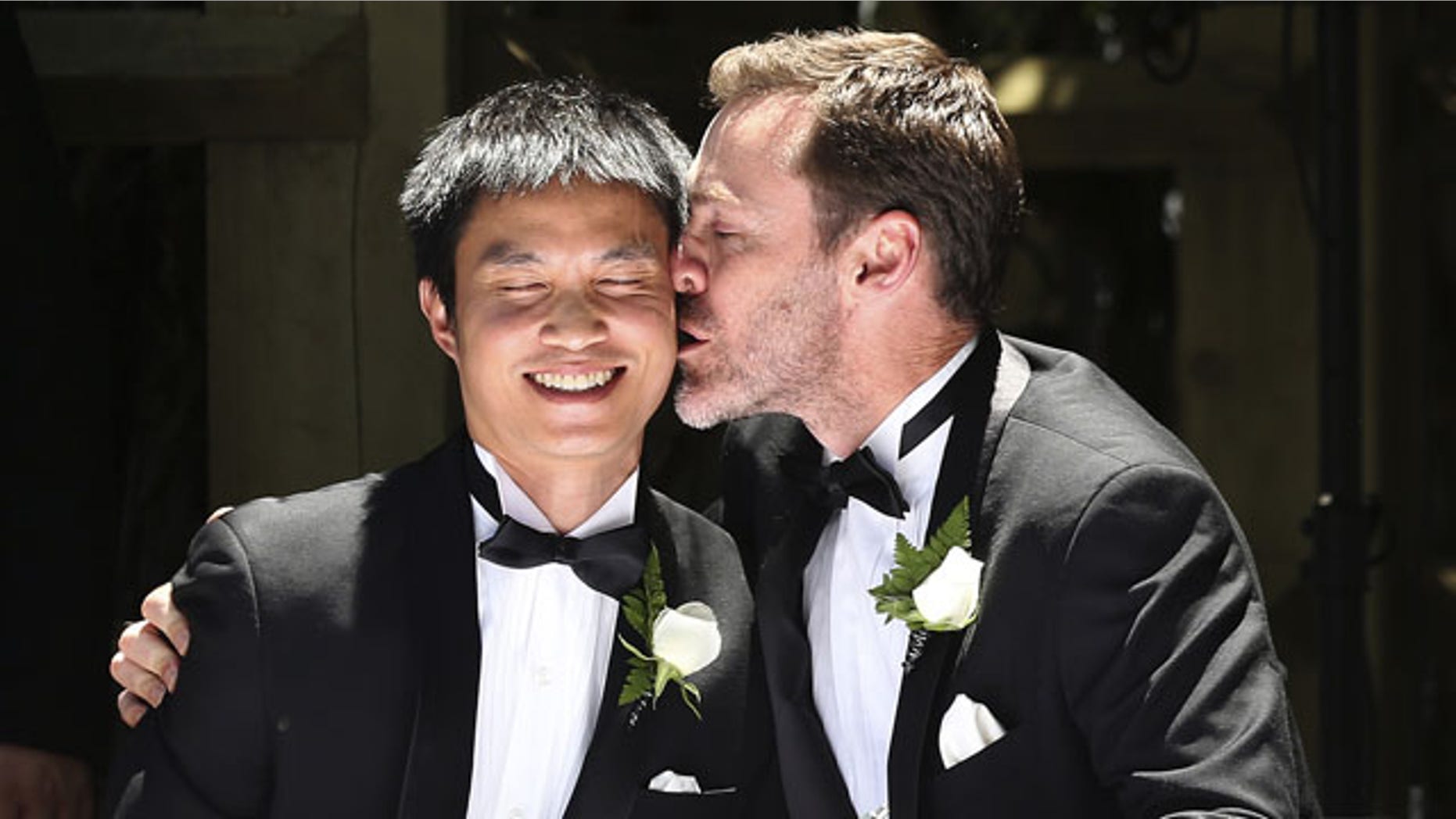 FILE - In this Dec. 7, 2013 file photo, Ivan Hinton, right, gives his partner Chris Teoh a kiss after taking their wedding vows during a ceremony at Old Parliament House in Canberra, Australia. Australia's highest court struck down a landmark law on Thursday, Dec. 12, 2013 that had begun allowing the country's first gay marriages. (AP Photo)