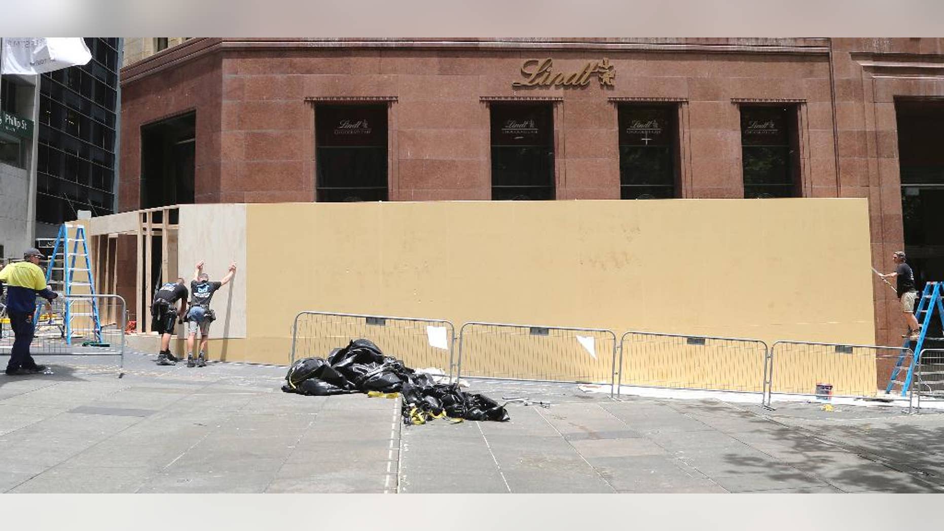 Dec. 23, 2014: Workers board up the Lindt Cafe in Martin Place in Sydney, Australia. Three people, including a gunman, were killed after police ended a siege in the central business district coffee shop in Sydney on Dec. 16. (AP Photo/Rob Griffith)