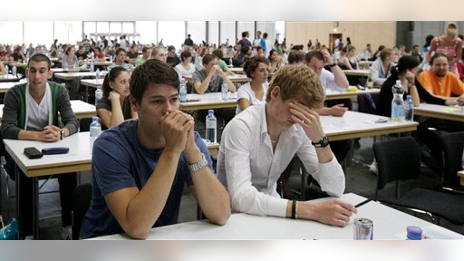 FILE - In this July 8, 2011 file photo applicants for the medical university sit in a hall of the Vienna Fair prior to their tests, in Vienna, Austria.