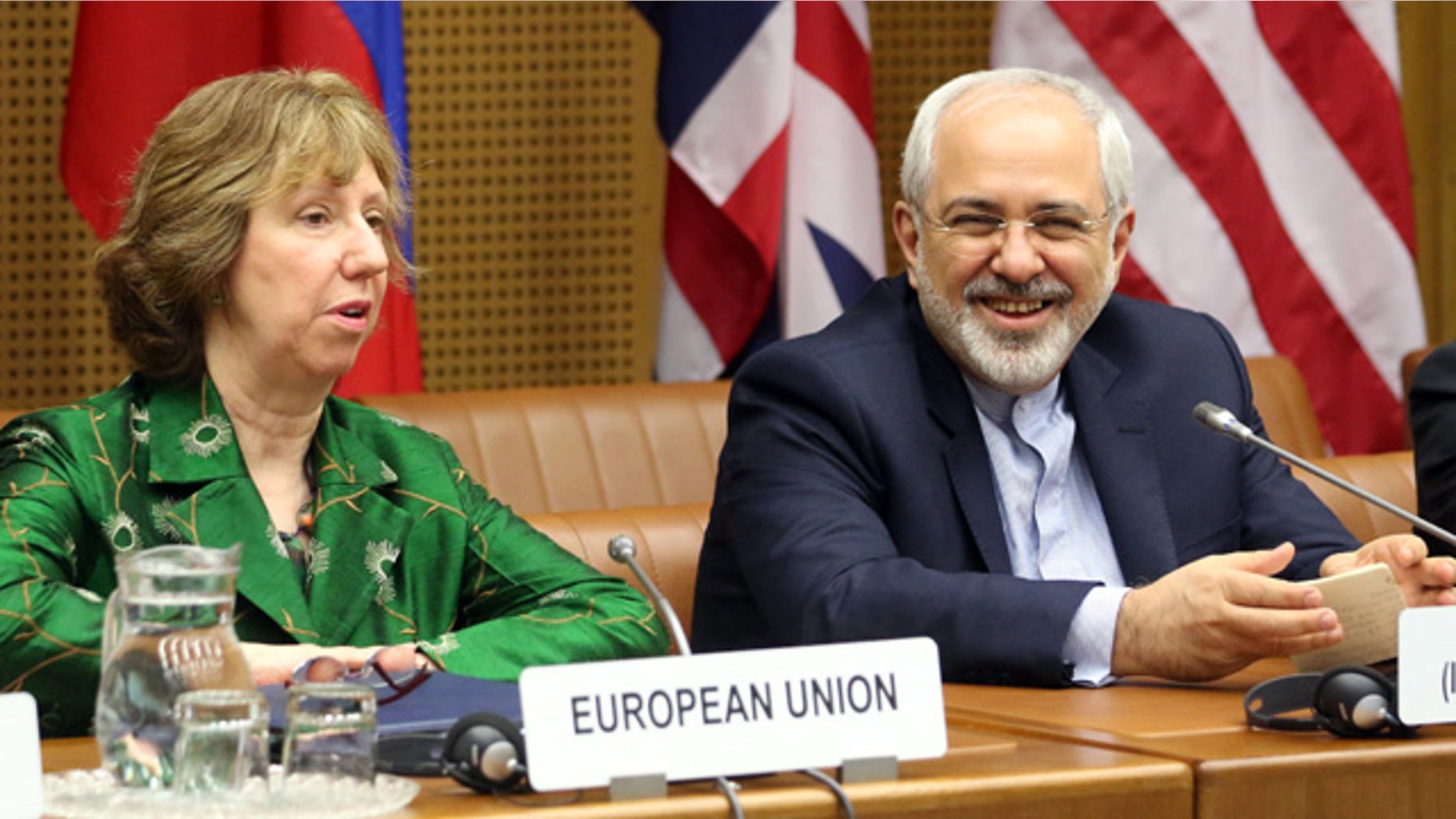 April 8, 2014: European foreign policy chief Catherine Ashton, left, and Iranian Foreign Minister Mohamad Javad Zarif, right, wait for the start of closed-door nuclear talks in Vienna, Austria. (AP Photo/Ronald Zak)