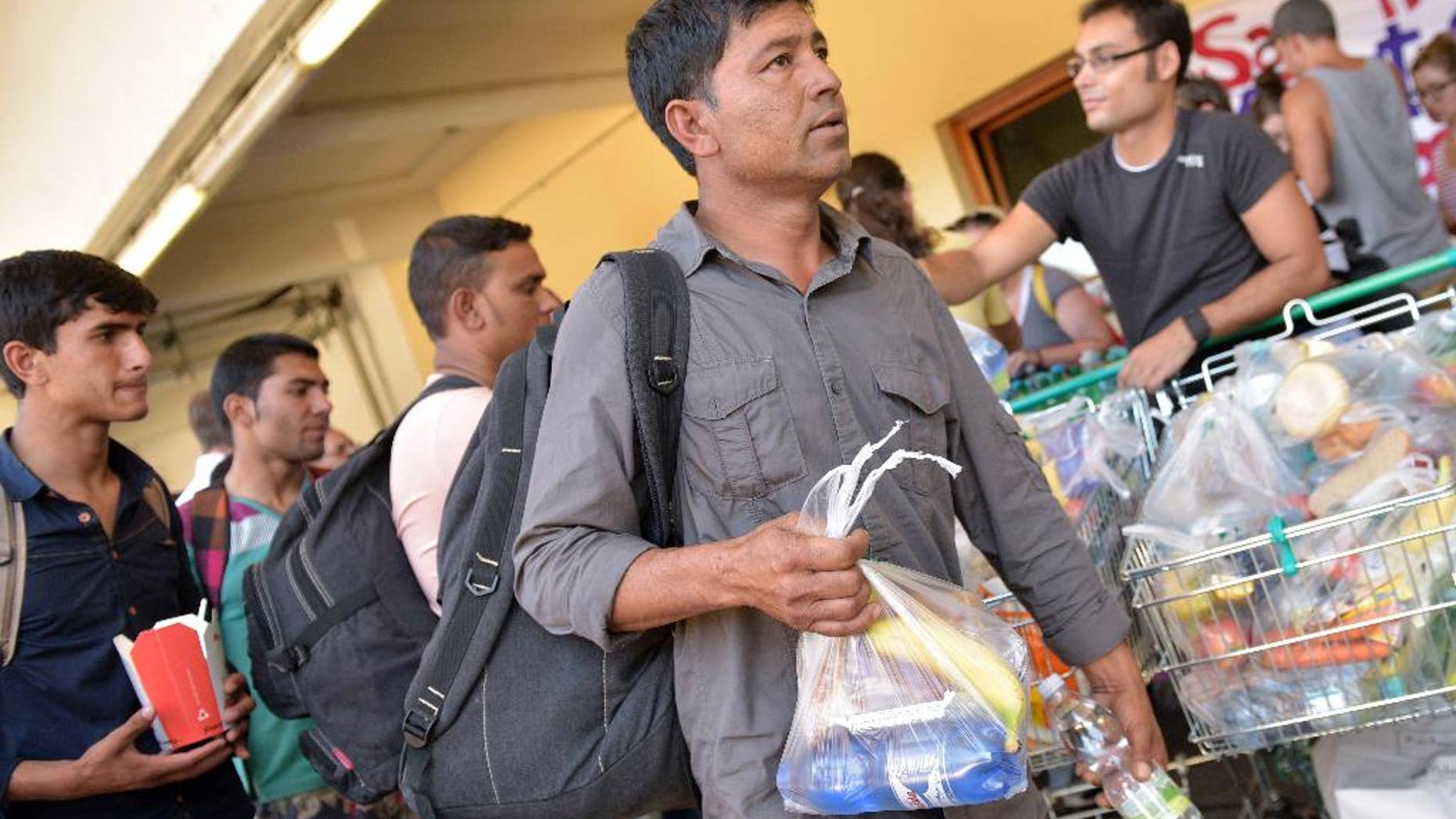 People receive food after they arrived at the Western railway station in Vienna, Austria, on Tuesday, Sept. 1, 2015. Some hundreds of migrants arrived by train from southern Europe, after making a perilous journey into Europe. (AP Photo/Hans Punz)