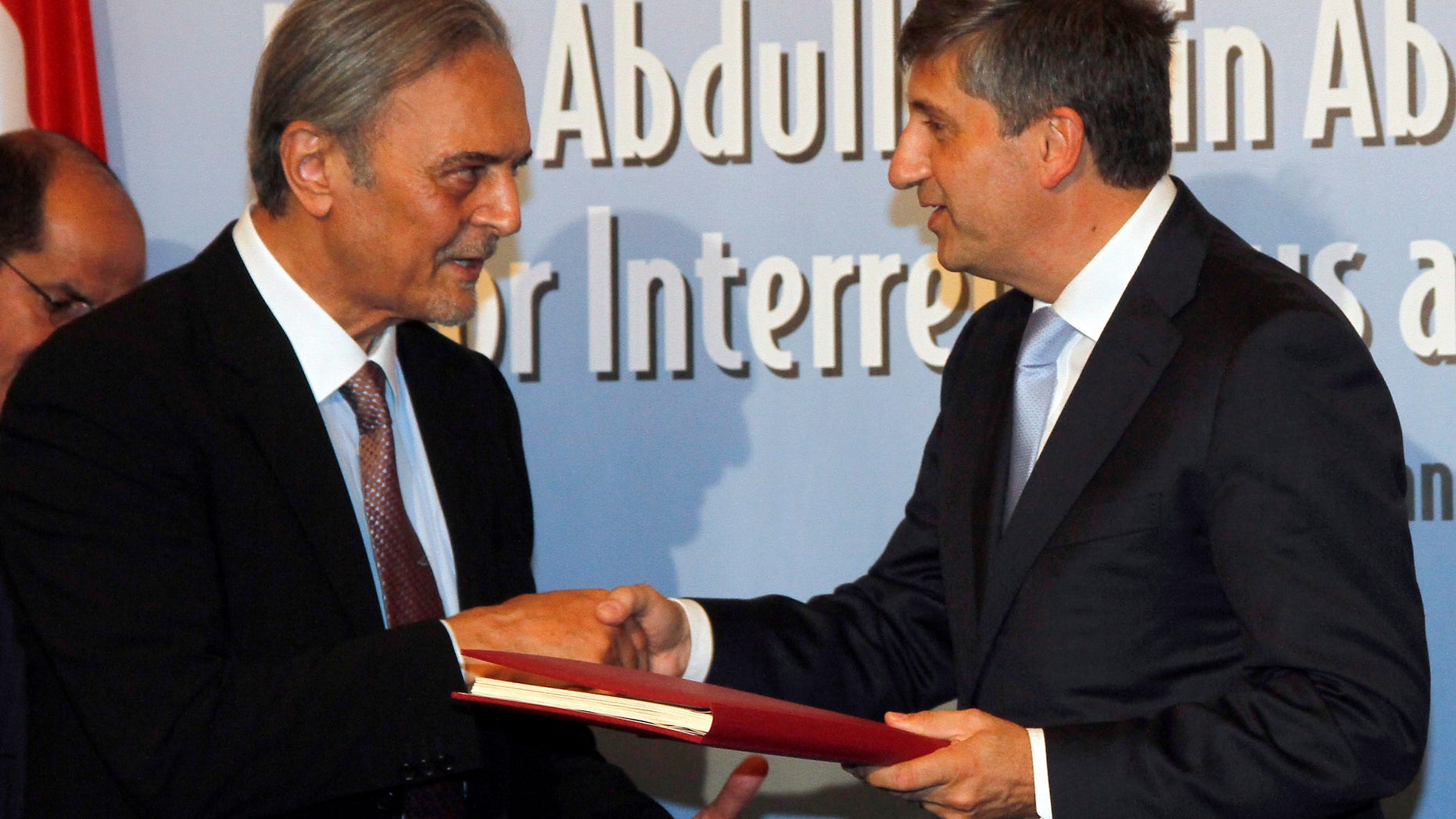 Saudi Arabia's Foreign Minister Prince Saud al-Faisal bin Abdulaziz Al Saud exchanges documents with his Austrian counterpart Michael Spindelegger, from left, after signing the agreement for the establishment of the King Abdullah Bin Abdulaziz International Center for Interreligious and Intercultural Dialogue, KAICID, in Vienna, Austria, Thursday, Oct. 13, 2011.
