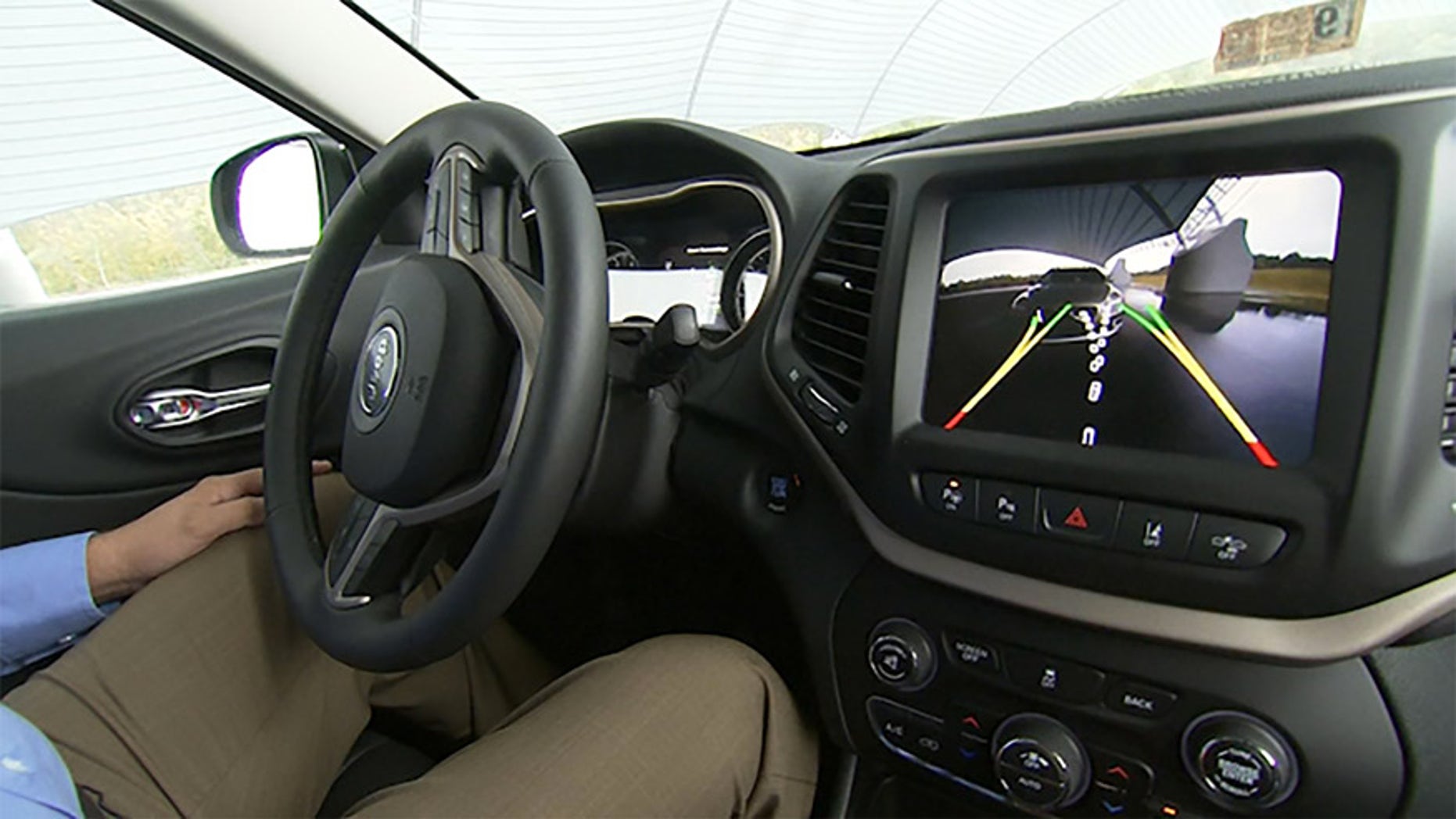 This image from video, taken Oct. 1, 2015, shows Insurance Institute for Highway Safety (IIHS) Senior Research Engineer David Aylor in the drivers seat with an electronic display on the dashboard for parallel parking assistance at the IIHS Vehicle Research Center in Ruckersville, Va. American car buyers are baffled by a blizzard of new safety technologies in vehicles that vary from manufacturer to manufacturer, from model to model, and from one options package to another. (AP Photo/Dan Huff)