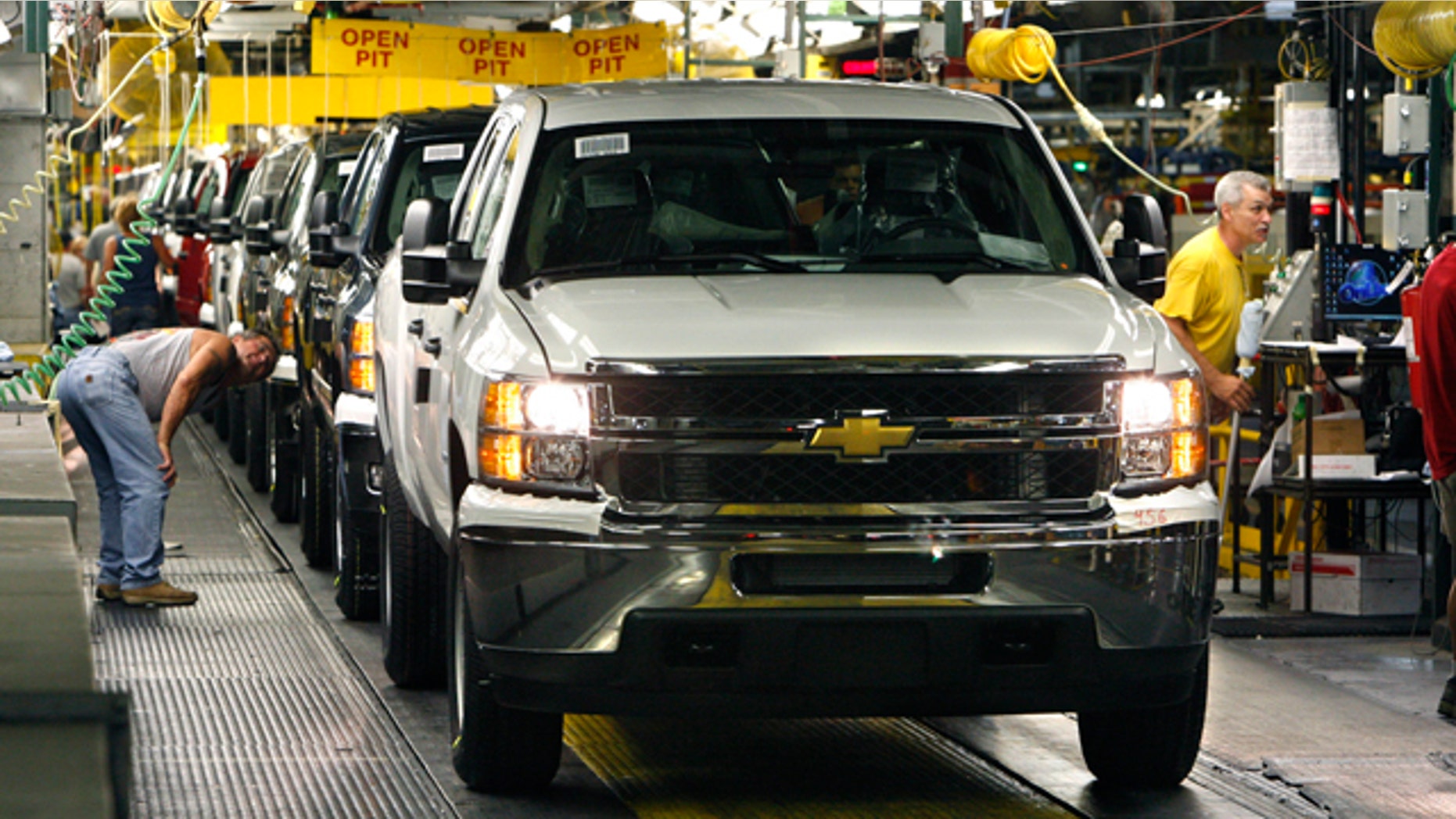 FILE- In this June 23, 2010 file photo, 2011 Chevrolet Silverado's await final inspection at the Flint Assembly in Flint, Mich. General Motors Co. says strong demand for its pickups and wagons lifted October sales 3.5 percent and helped the automaker overcome weak car sales. (AP Photo/Carlos Osorio, FILE)