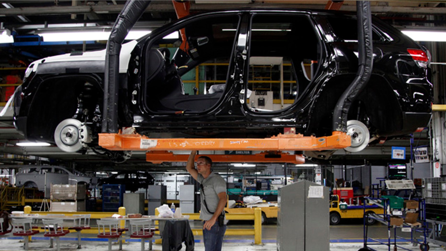 May 8, 2013: Jeff Caldwell, 29, right, a chassis assembly line supervisor, checks a vehicle on the assembly line at the Chrysler Jefferson North Assembly plant in Detroit.