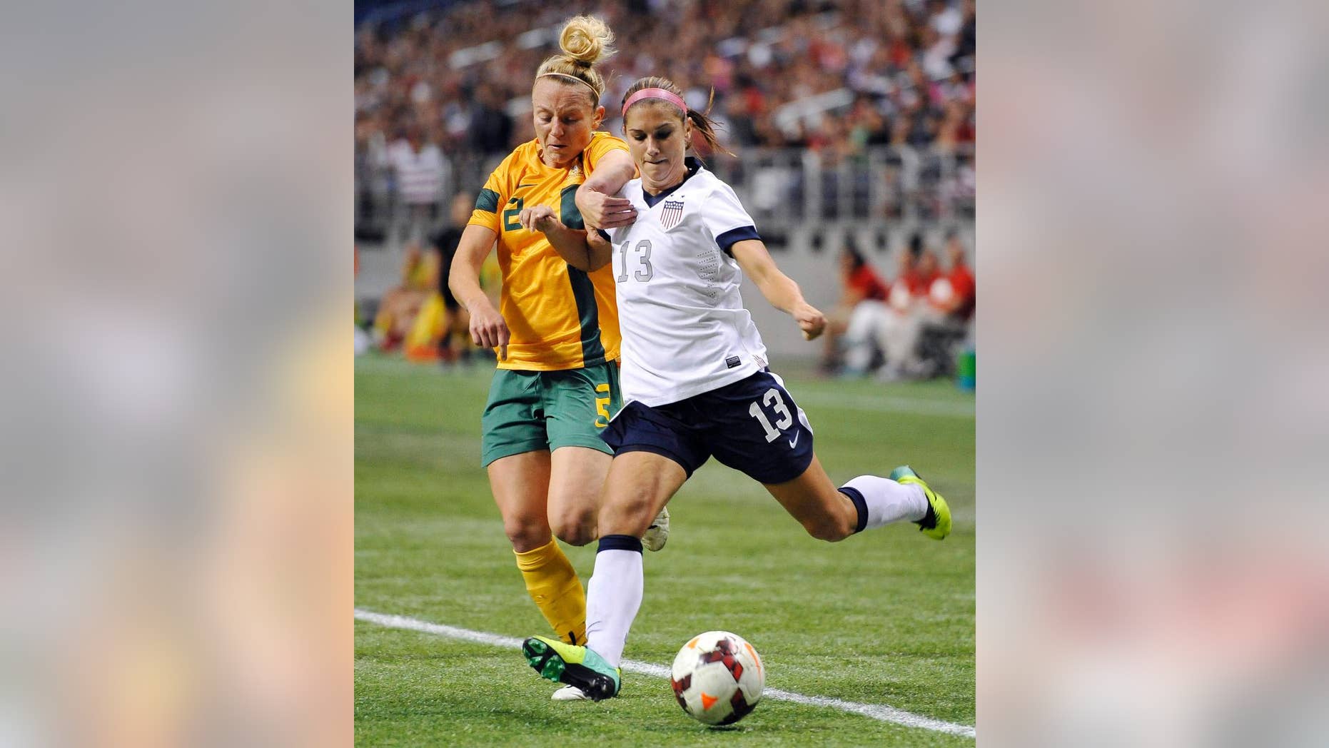 FILE - In this Oct. 20, 2013 file photo, USA forward Alex Morgan, right, tangles with Australia defender Teigen Allen during the first half of an international friendly women's soccer match in San Antonio. Portland’s NWSL team is struggling without its star forward as she rehabs from a left ankle injury she sustained while training with the U.S. national team last fall. Morgan is oh-so-close close to her return.(AP Photo/Darren Abate, File)