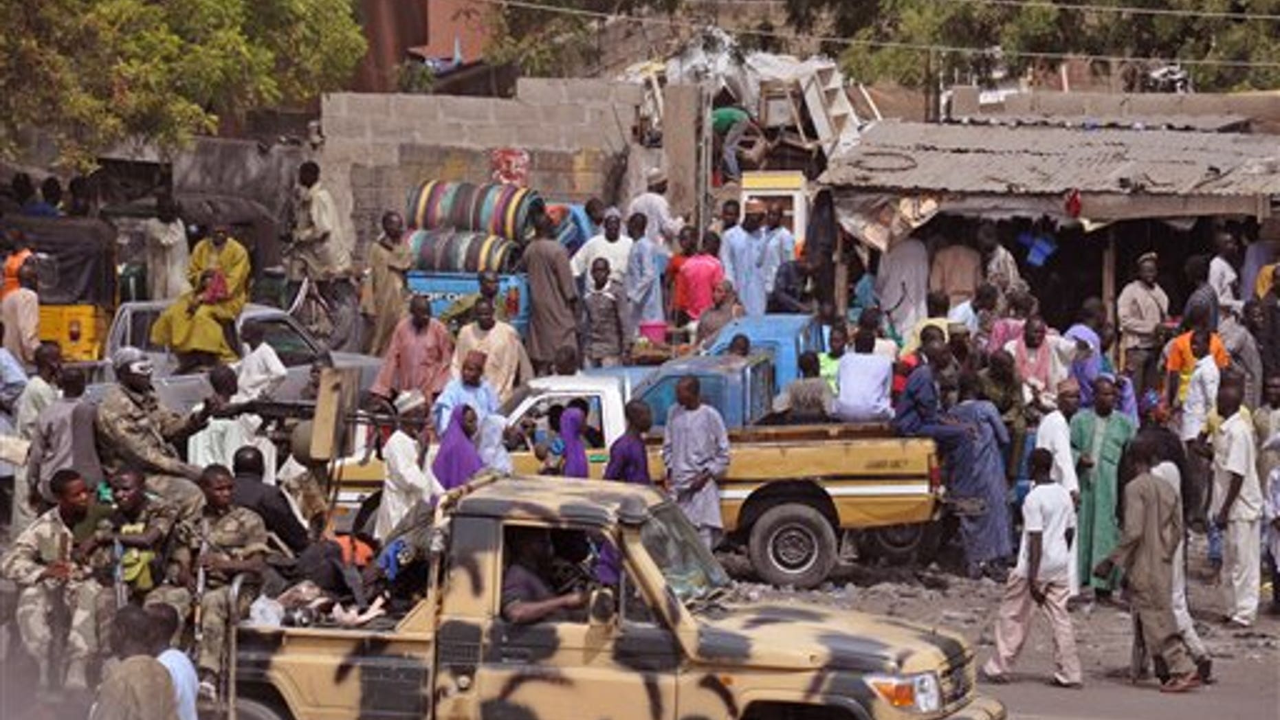 FILE - In this file photo taken Tuesday, Jan. 27, 2015, Nigerian soldiers, left, pass by on the back of an armed truck as they patrol a local market after . Nigerian jets bomb Boko Haram out of a slew of northeastern Nigerian towns and villages. (AP Photo/Jossy Ola, File)