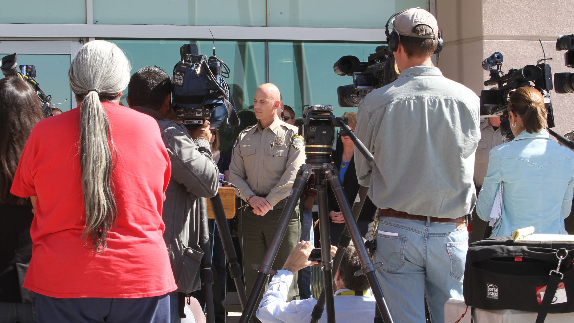 Pinal County Sheriff Paul Babeu, center, speaks at a news on Feb. 18 in Florence, Ariz. (AP Photo/The Arizona Republic, Deirdre Hamill)