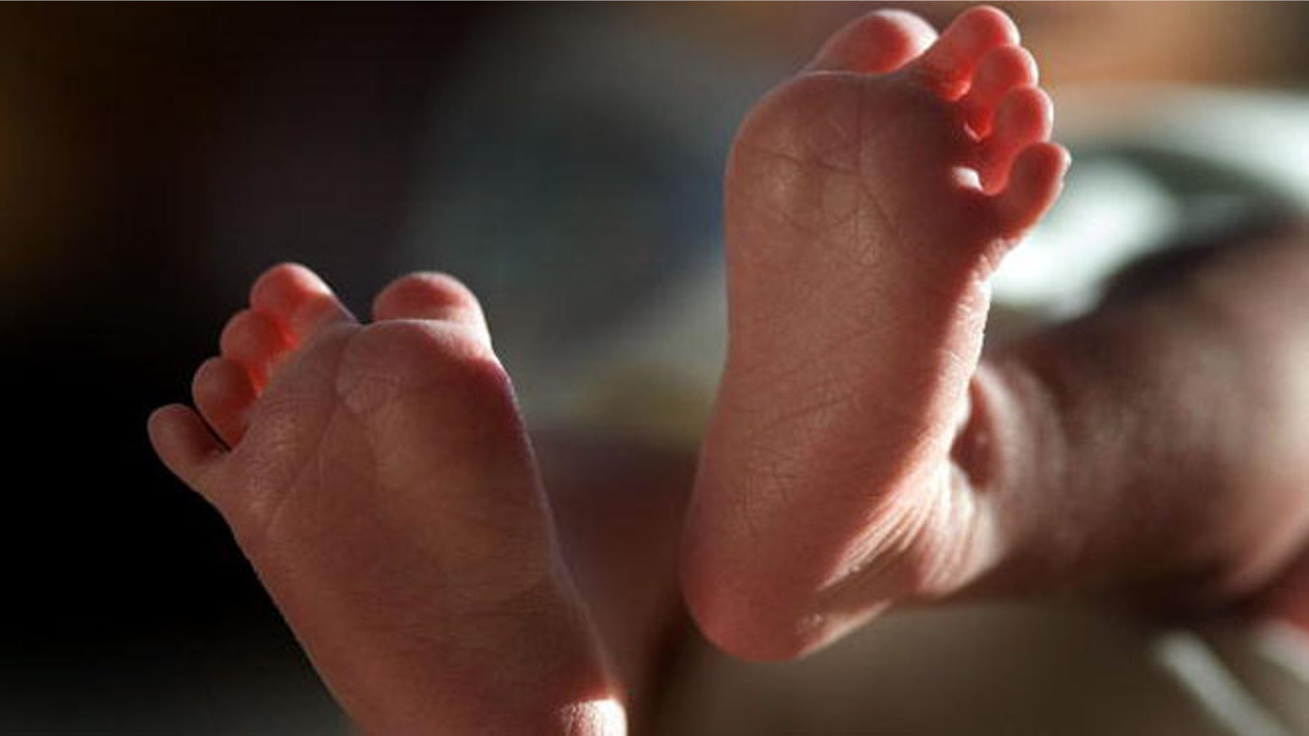 KNUTSFORD, UNITED KINGDOM - APRIL 03: (FILE) In this file photograph taken on March 20, 2007, a two-week-old boy finds his feet in his new world. Health Secretary Patricia Hewitt announced, April 3, 2007 that for the first time, mothers-to-be will have a guarantee that the NHS will provide them with a full range of birthing choices - including home births - and a midwife they know and trust to care for them. (Photo by Christopher Furlong/Getty Images)