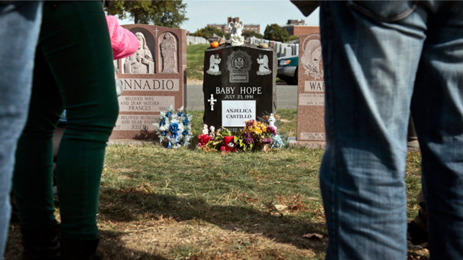 Visitors gather at the grave of Baby Hope, Anjelica Castillo, on Monday, Oct. 14, 2013 in the Bronx borough of New York.