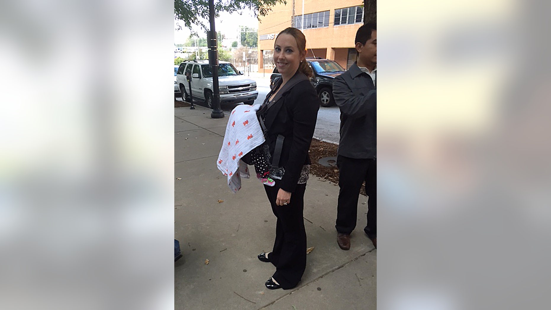 In this Oct 7, 2014 photo released by Stacy Ehrisman-Mickle, Ehrisman-Mickle poses for a photo with her daughter, in Atlanta. Ehrisman-Mickle, an immigration lawyer, brought her 4-week-old baby to court after Immigration Judge J. Dan Pelletier Sr. denied her request to delay a hearing that fell during her maternity leave. During the hearing, her baby began to cry, and Pelletier scolded her for inappropriate behavior. (AP Photo/Stacy Ehrisman-Mickle)