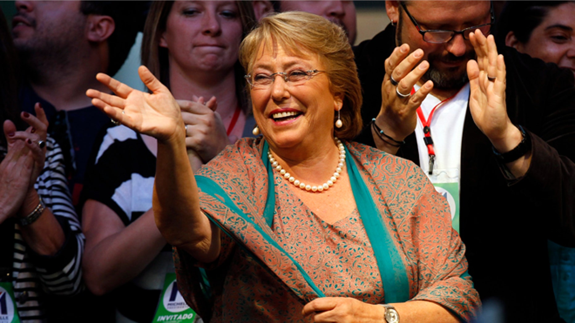 Presidential candidate Michelle Bachelet waves during a victory rally in Santiago, Chile, Sunday, Dec. 15, 2013. With 90 percent of the votes counted, Bachelet had an unbeatable 62 percent to 38 percent for the center-right's Evelyn Matthei, who has conceded defeat. (AP Photo/Luis Hidalgo).