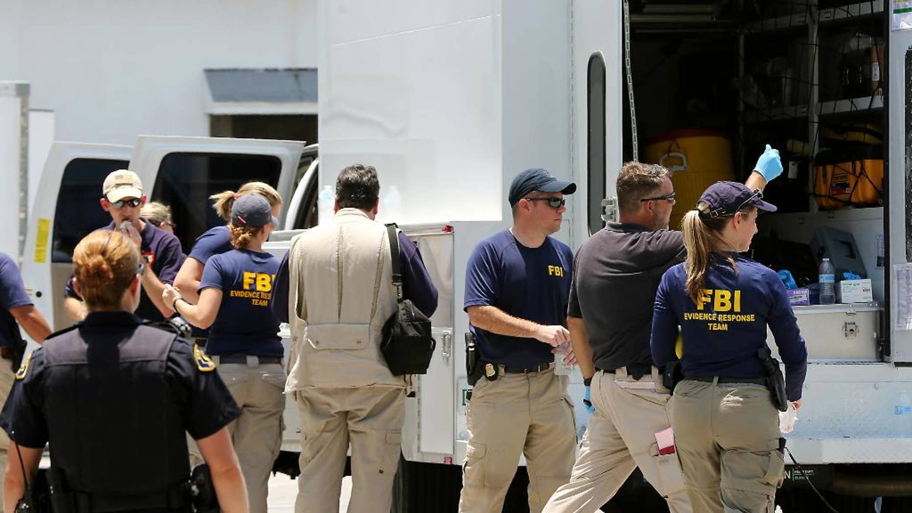 In this photo taken on Monday, July 27, 2015, federal agents and Key West Police gather in a restaurant parking lot in Key West, Fla. A man described by the FBI as an Islamic State sympathizer who hoped to mount attacks on U.S. soil was charged Tuesday with plotting to detonate a nail-filled backpack bomb on a Florida beach. (Rob O'Neal/The Key West Citizen via AP) MIAMI OUT; MANDATORY CREDIT