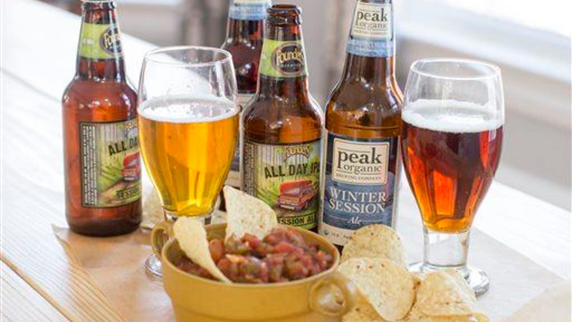 This Dec. 8, 2014, photo shows lower alcohol craft beers Founders All Day IPA and Peak Organic Winter Session Ale in Concord, N.H.