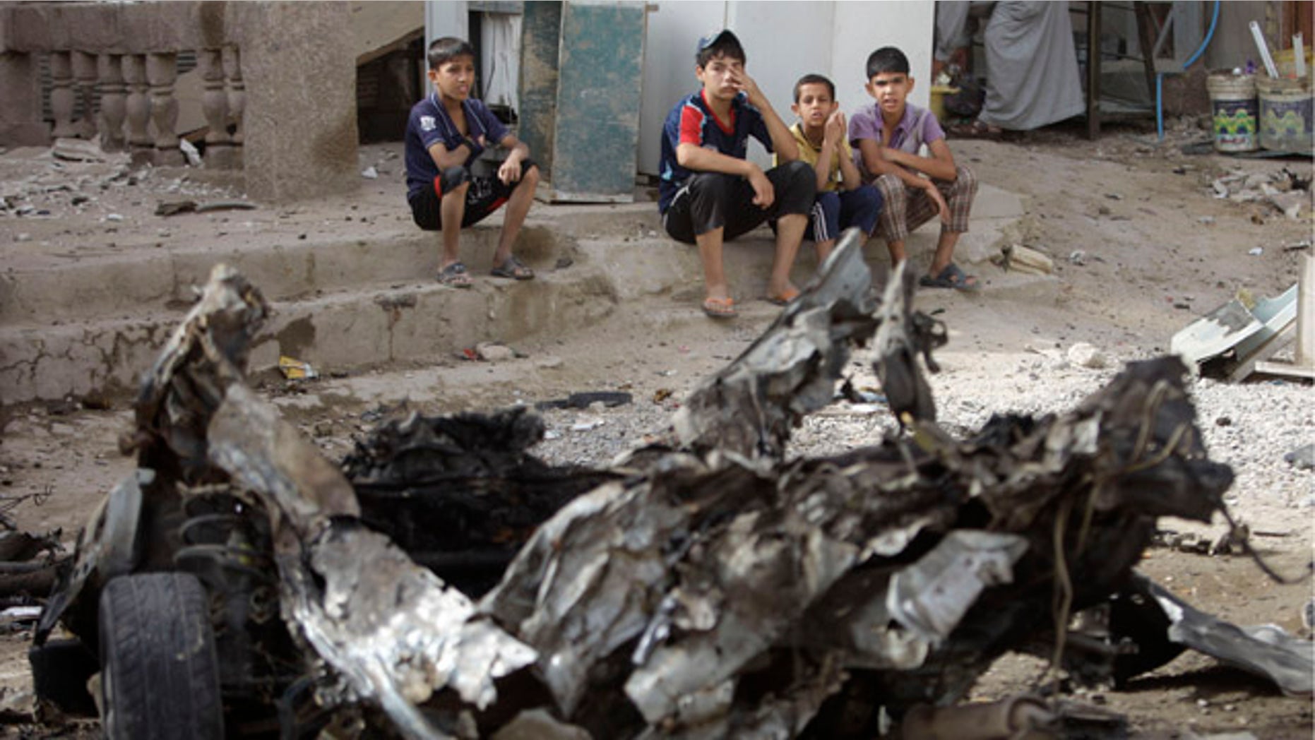 May 22: Boys sit near the scene of a car bomb attack in Baghdad, Iraq. A rapid-fire series of explosions in Baghdad while Iraqis were going to work on Sunday morning killed and wounded scores of people, police said