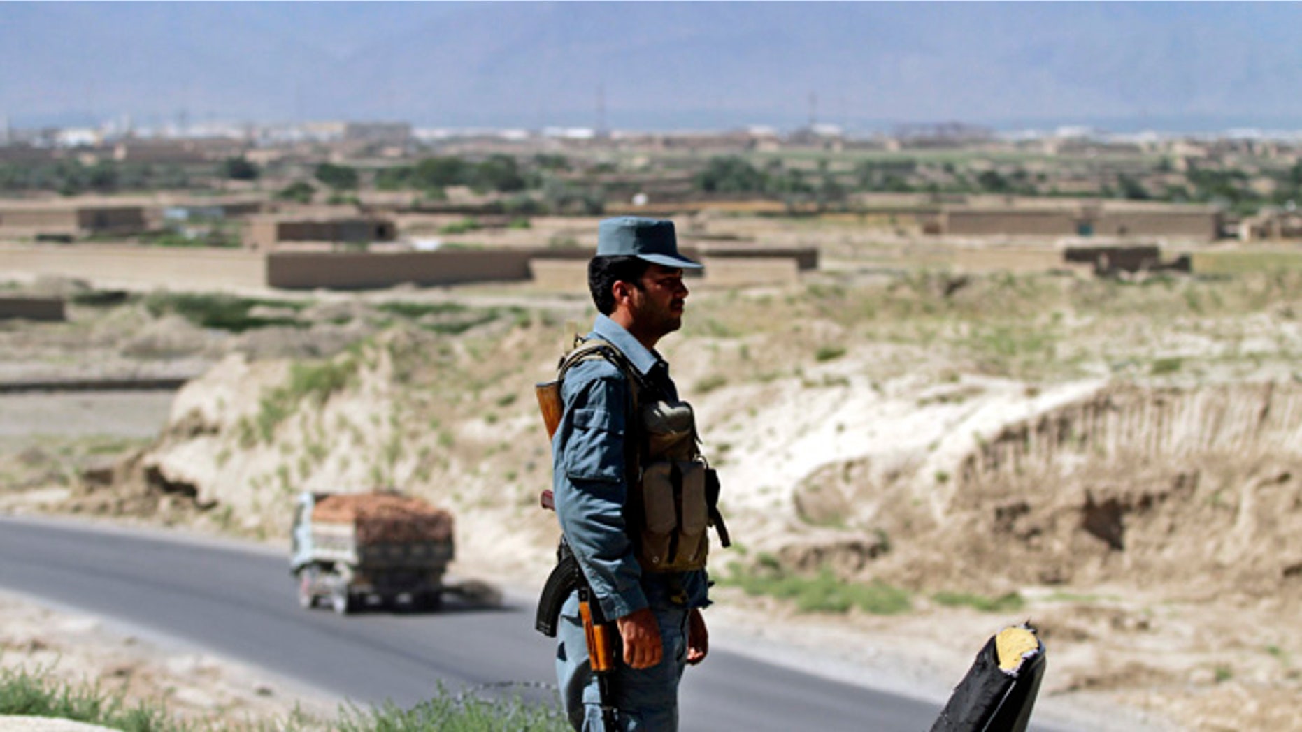 June, 19, 2013: An Afghan policeman stand guard outside Bagram military base, 31 miles north of Kabul, Afghanistan. The Taliban claimed responsibility Wednesday for an attack in Afghanistan that killed four American troops just hours after the insurgent group announced it would hold talks with the U.S. on finding a political solution to ending the nearly 12-year war in the country.