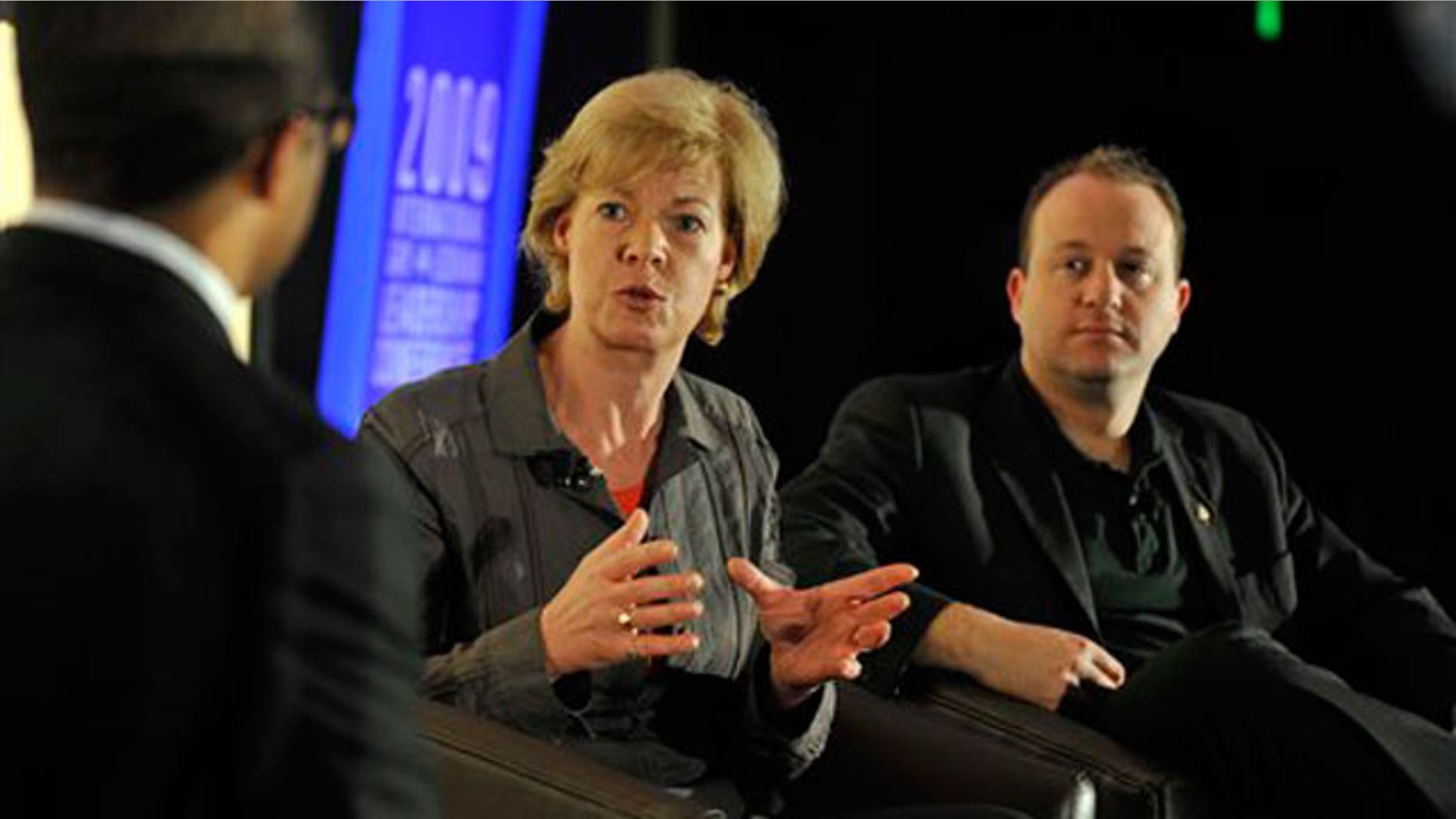 FILE: U.S. Rep. Tammy Baldwin, center, and U.S. Rep. Jared Polis, right, both openly gay members of Congress.