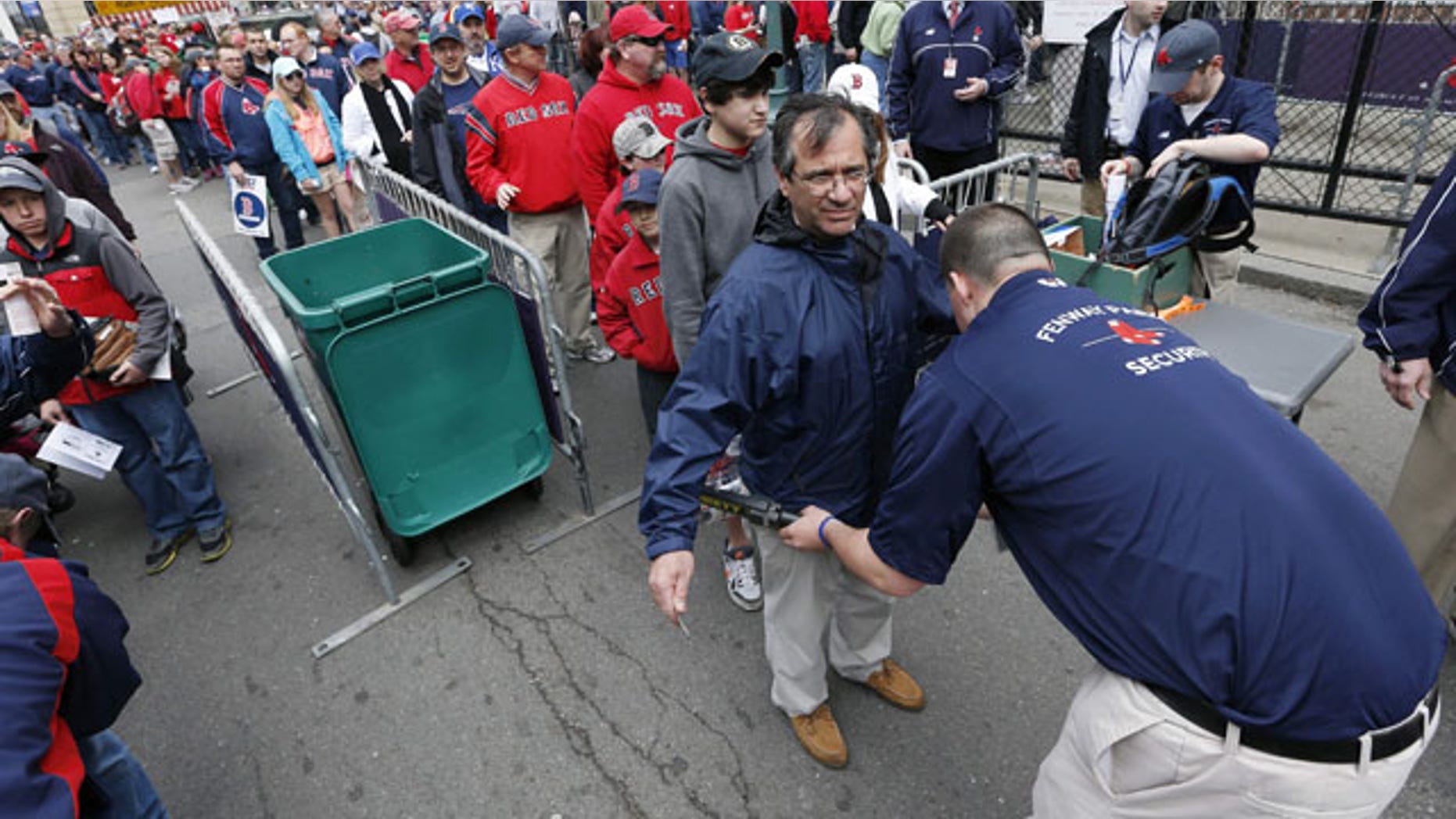FILE - In this April 20, 2013 file photo, fans pass through security before entering Fenway Park for a baseball game between the Boston Red Sox and the Kansas City Royals in Boston. Major League Baseball has told its 30 teams they must implement security screening for fans by 2015. (AP Photo/Michael Dwyer, File)