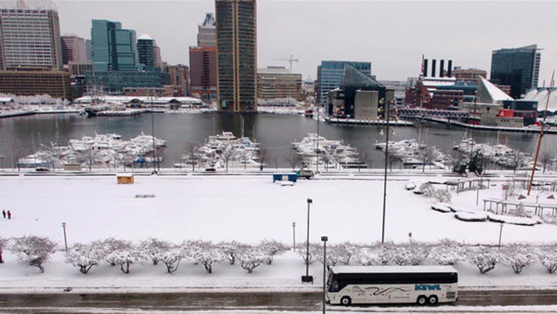 FILE: Pedestrians make their way with downtown Baltimore in the background.