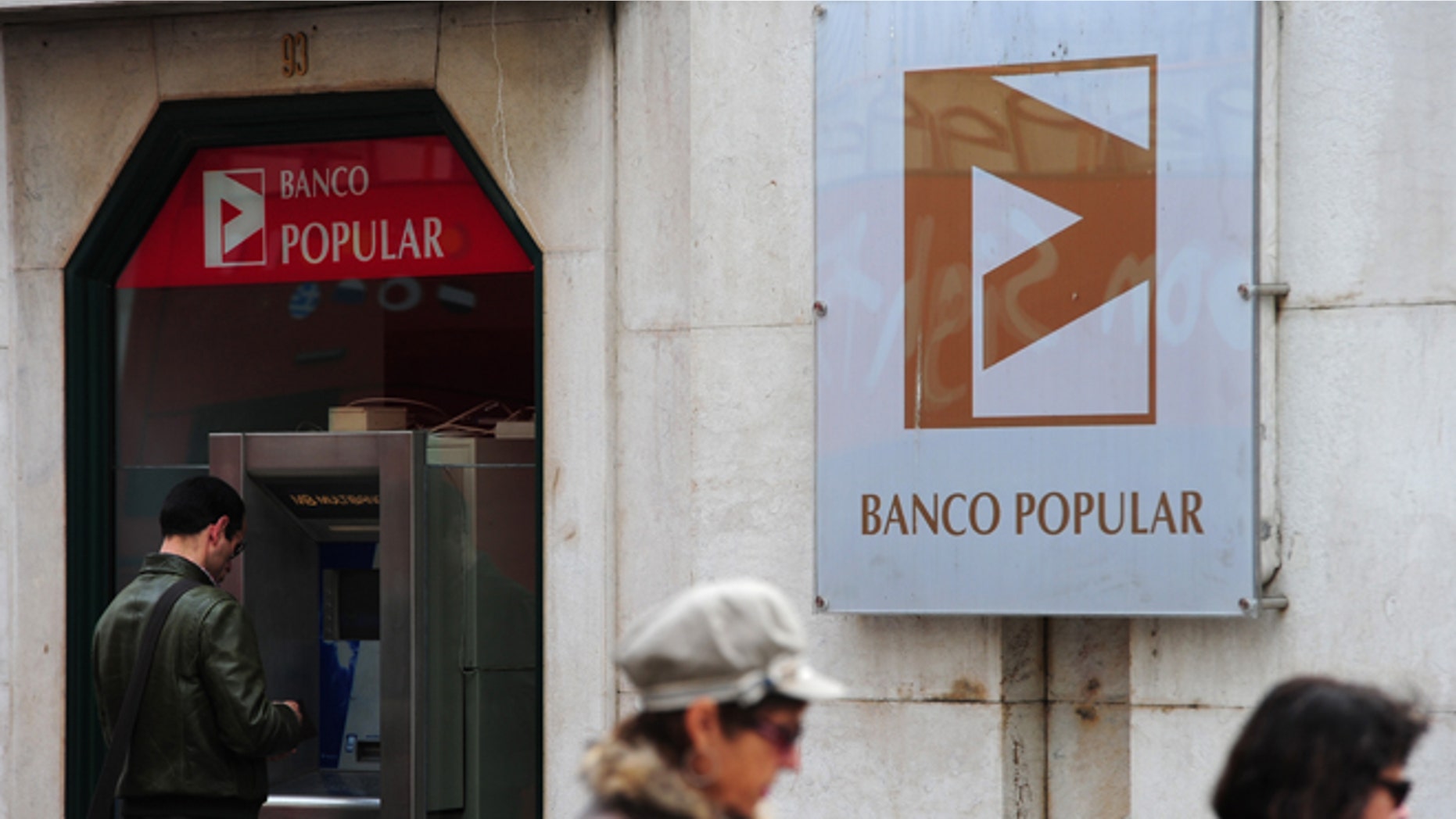 LISBON, PORTUGAL - MARCH 29: A man stands behind a cash machine of the Banco Popular on March 29, 2011 in Lisbon, Portugal. The pressure continues on Portugal's weak economy to accept a bailout - estimated to be as high as 80 Million Euros - after last week's resignation of Prime Minister Jose Socrates. (Photo by Jasper Juinen/Getty Images)