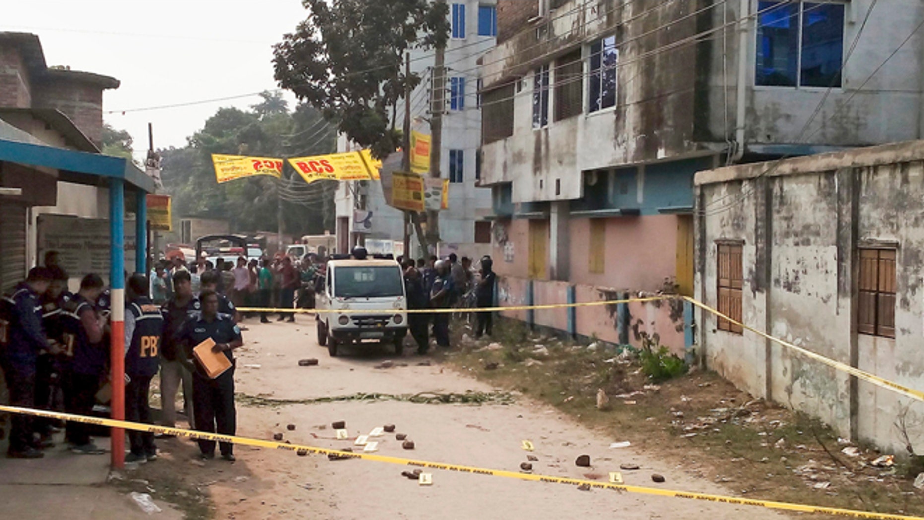 Nov. 18, 2015: Members of Bangladesh's Police Bureau of Investigation stand by the site where an Italian priest was attacked.
