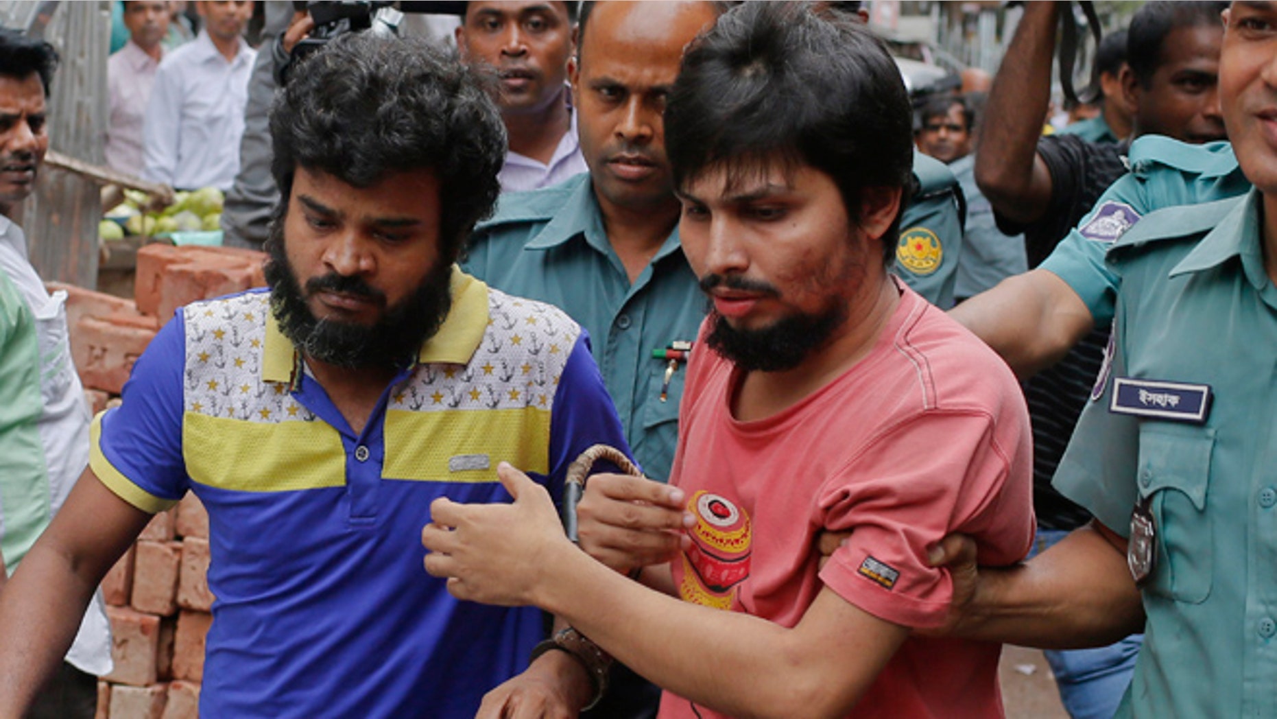 Suspected members of the banned Islamic militant outfit Ansarullah Bangla Team, Sadek Ali, second right, and Aminul Mollick, front left, are escorted by policemen along with another suspect from a court in Dhaka, Bangladesh.