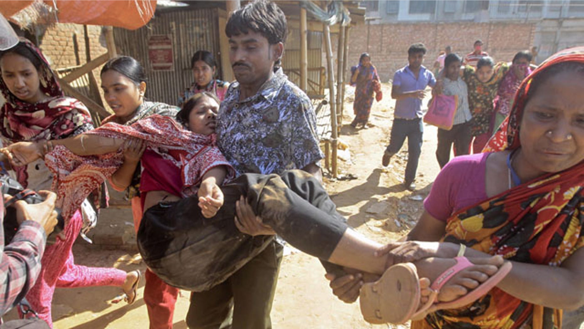 November 12, 2013: Bangladeshi garment workers assist their colleagues injured during a clash with police in Ashulia, outskirts of Dhaka, Bangladesh. Thousands of garment workers demanding higher pay clashed with police for a second day Tuesday, leaving dozens of people injured and at least 200 factories closed, police said. (AP Photo/A.M. Ahad)