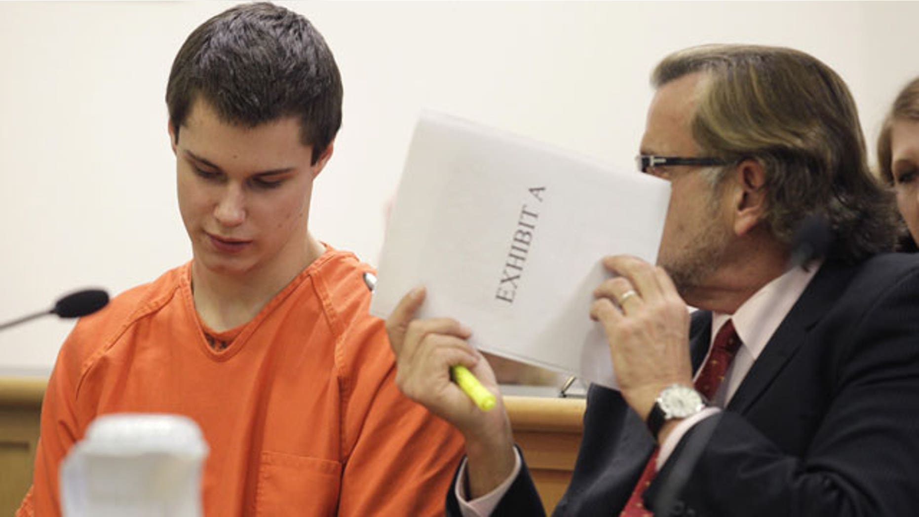 December 16, 2011: Attorney John Henry Browne, right, uses a court document to shield his conversation with Colton Harris-Moore, in Island County Superior Court in Coupeville, Wash. Harris-Moore was later sentenced to more than seven years in prison after pleading guilty to dozens of state charges stemming from a two-year crime spree.