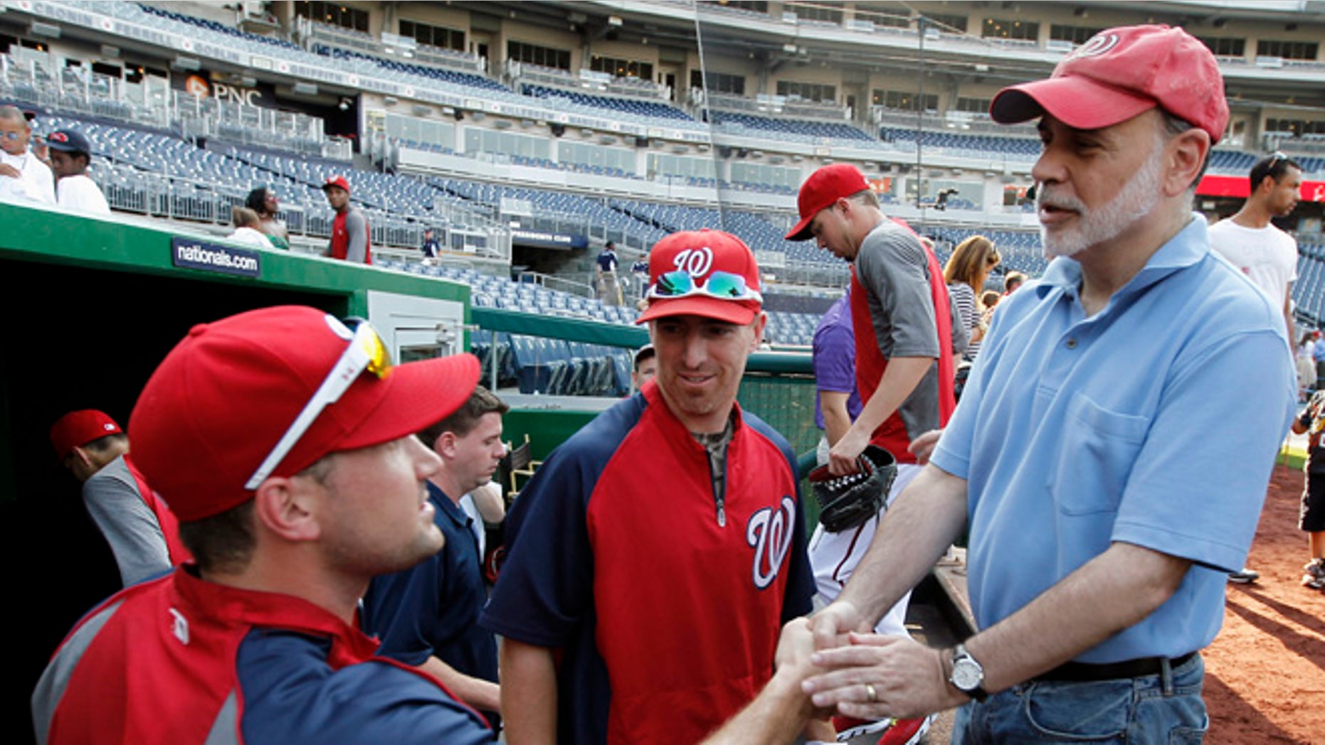 Washington Nationals third baseman Ryan Zimmerman, left, and first baseman Adam LaRoche, center, greeting Federal Reserve Board Chairman Ben Bernanke before a baseball game against the Miami Marlins at Nationals Park in Washington.