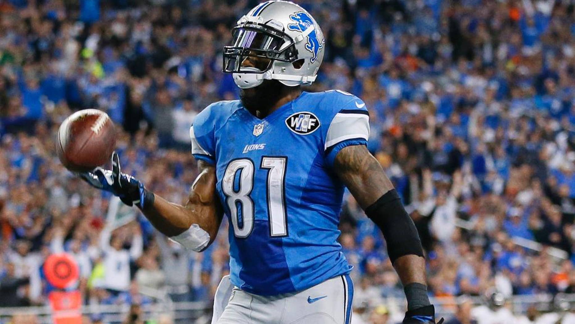 Detroit Lions wide receiver Calvin Johnson tosses the ball after his 25-yard reception for a touchdown during the first half of an NFL football game against the Chicago Bears in Detroit, Thursday, Nov. 27, 2014. (AP Photo/Rick Osentoski)