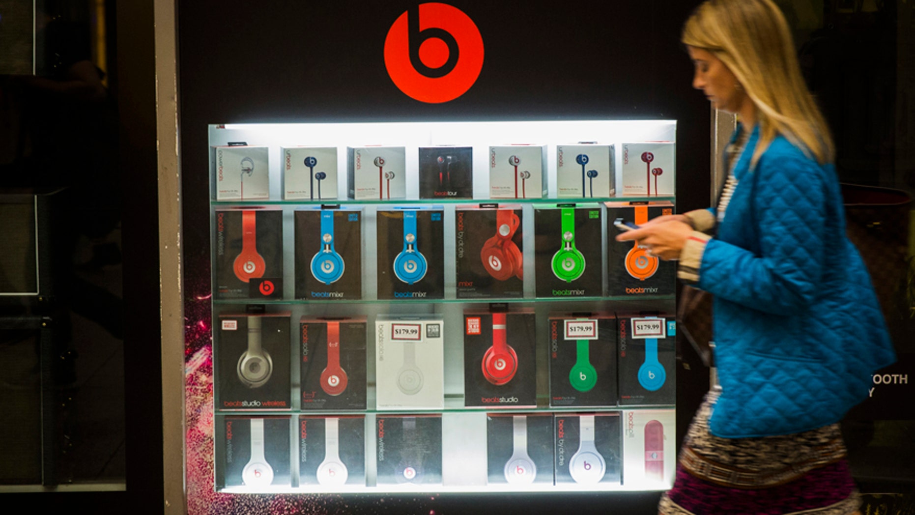 A pedestrian walks past a Beats brand display in the subway system of New York, May 29, 2014.