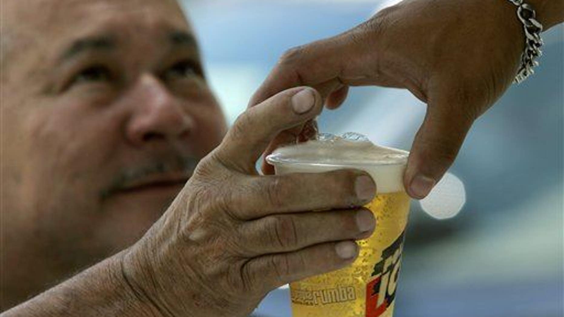 A man buys beer in an outdoor bar at Caracas's auto show, Sunday, Oct 7, 2007. Venezuela's President Hugo Chavez is on a moral crusade, preaching against vices from alcohol to cholesterol, vowing to curb whisky imports and ordering beer trucks off the street.