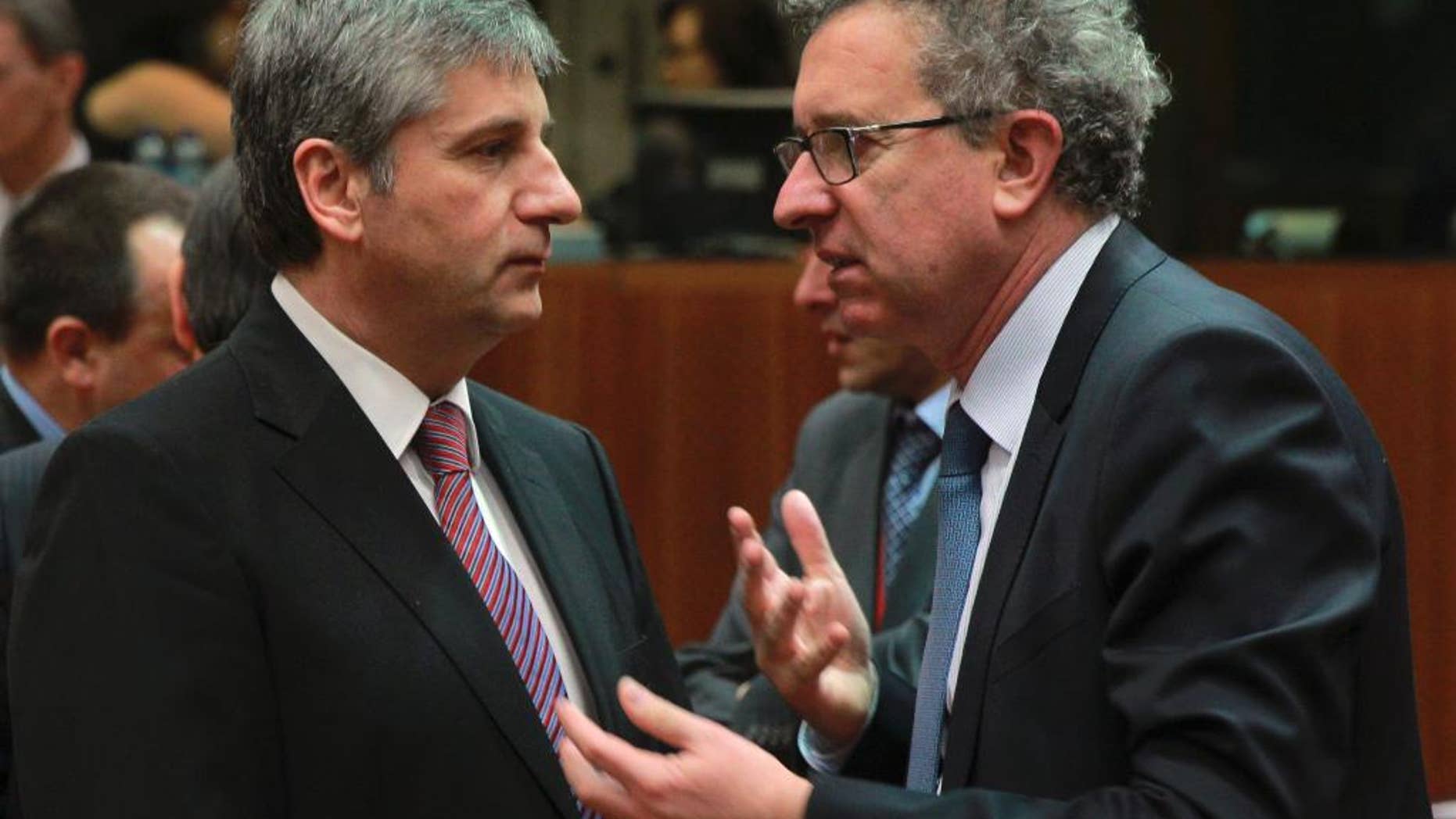 Austrian Finance Minister Michael Spindelegger, left, talks with his Luxembourg's counterpart Pierre Gramegna at the start of an EU finance ministers meeting at the European Council building in Brussels, Tuesday, March 11, 2014. The Council prepares the presidency's mandate to finalize negotiations with the European Parliament on the proposal for a single resolution mechanism for banks. (AP Photo/Yves Logghe)