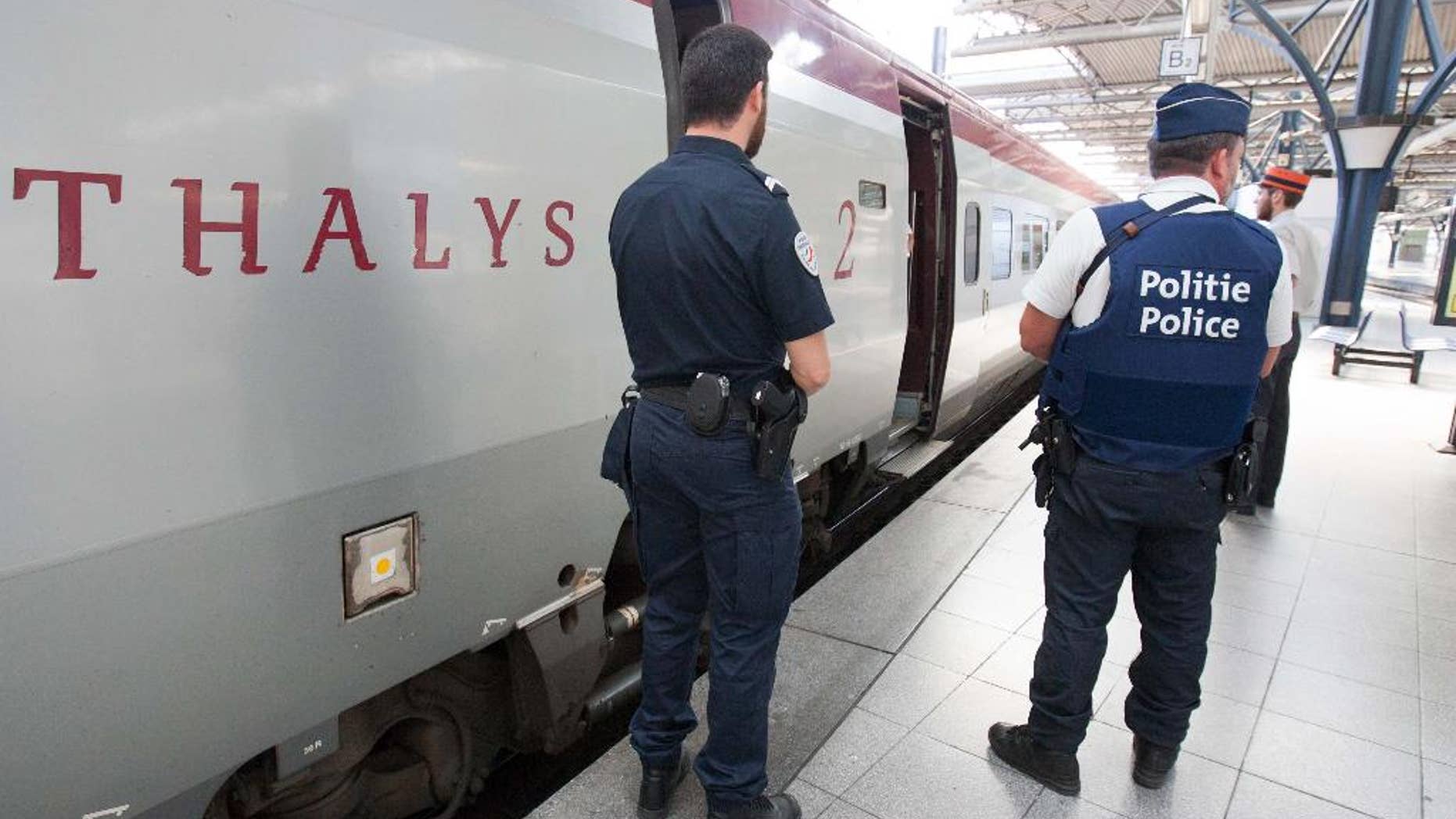 FILE - In this Aug.22, 2015 file photo, member of Belgian and French police stay next to a Thalys train at the Brussels Midi - Zuid train station. The attack Aug. 21 on the Thalys train from Amsterdam to Paris happened at the height of the summer travel season. France hosts emergency talks in Paris on Saturday, with representatives from other high-speed international rail nations, Belgium, Britain, Germany, Italy, Luxembourg, the Netherlands, Spain and Switzerland. (AP Photo/Francois Walschaerts, File)