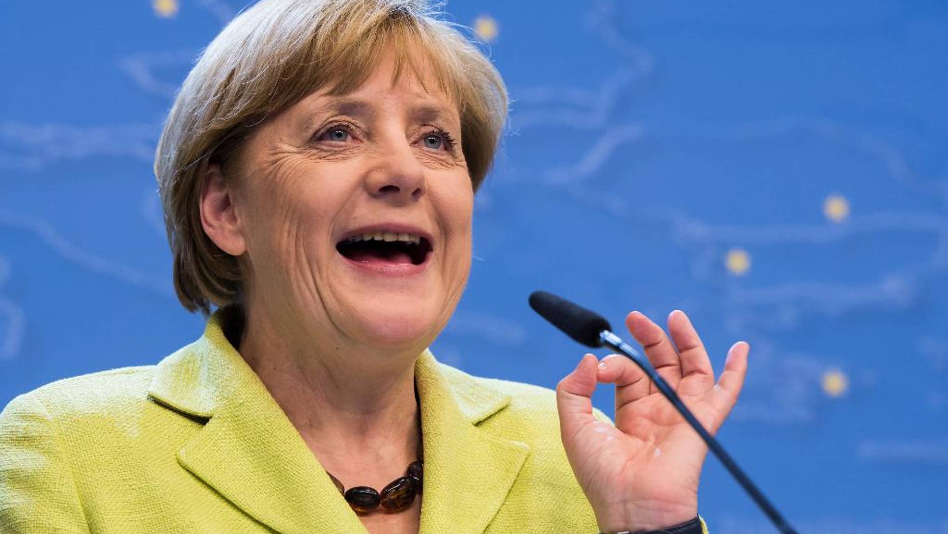 German Chancellor Angela Merkel addresses the media at the end of an EU summit at the European Council building in Brussels, early Thursday, July 17, 2014. European Union leaders ordered tougher sanctions against Russia early Thursday because of its actions in Ukraine, asking the European Investment Bank to sign no new financing agreements with Moscow. The leaders, meeting in Brussels, also agreed to act together to suspend financing of the new European Bank for Reconstruction and Development operations in Russia. (AP Photo/Geert Vanden Wijngaert)