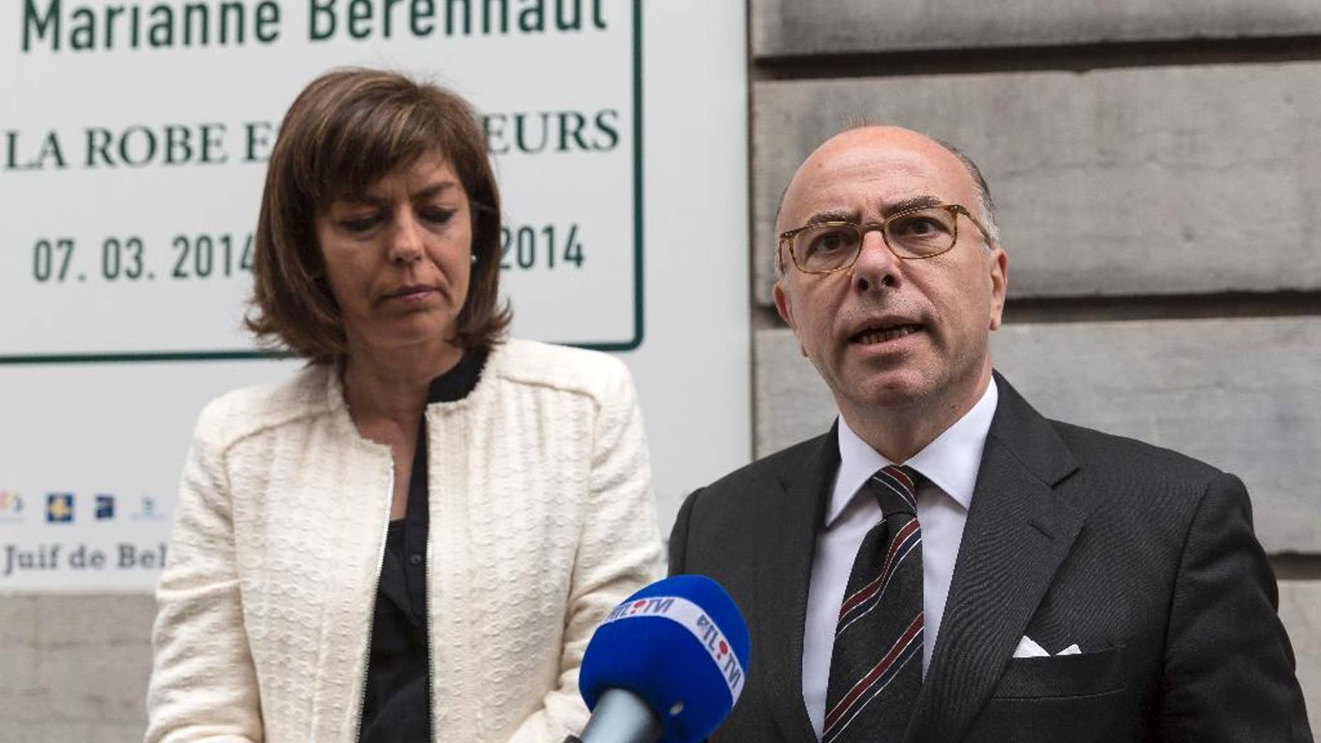 FILE - In this June 4, 2014 file photo, French Interior Minister Bernard Cazeneuve, right, and Belgium's Interior Minister Joelle Milquet speak with the press after laying a wreath at the Jewish Museum in Brussels on Wednesday, June 4, 2014. Recruiters for Islamic extremist groups are increasingly targeting French women and girls, with nearly 100 either in Syria or on their way and 175 being monitored at home, security officials say. France’s Interior Ministry on Tuesday Sept.16, 2014 posted a video showing anguished family members of young people who left to fight alongside extremists, including a young man whose 15-year-old sister set out for what she thought was a humanitarian aid mission. She has not returned. (AP Photo/Thierry Monasse, File)
