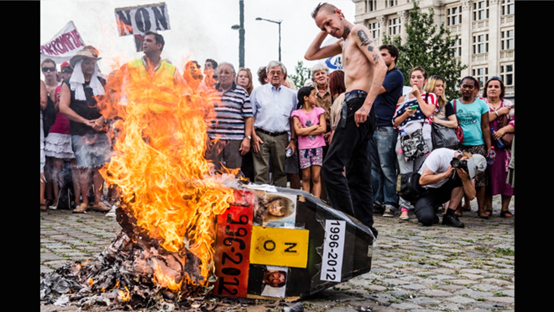 Aug. 19, 2012: Demonstrators gather around a burning mock coffin with the pictures of Belgium's child killer Marc Dutroux and his ex-wife Michelle Martin during a march to remember their victims, in Brussels.